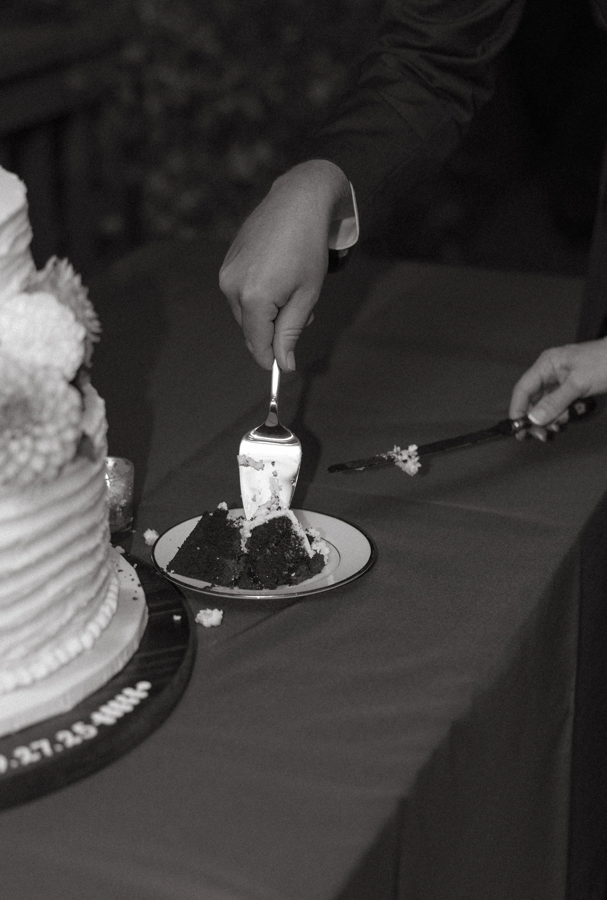 Person cutting a piece of cake at a celebration or event.