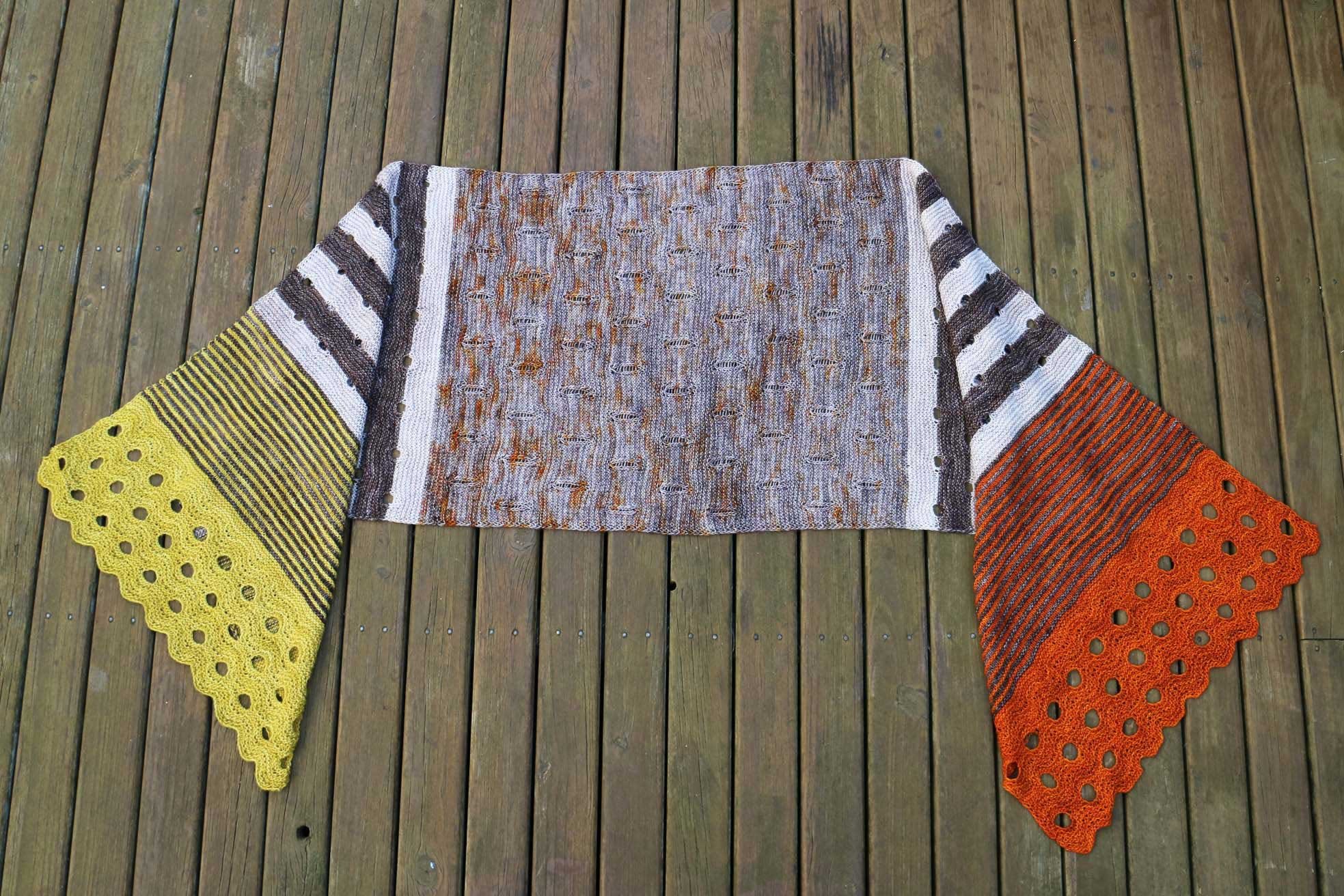 Full view of Fibrefest Shawl knit pattern in five colours with mirrored sections at each end.
