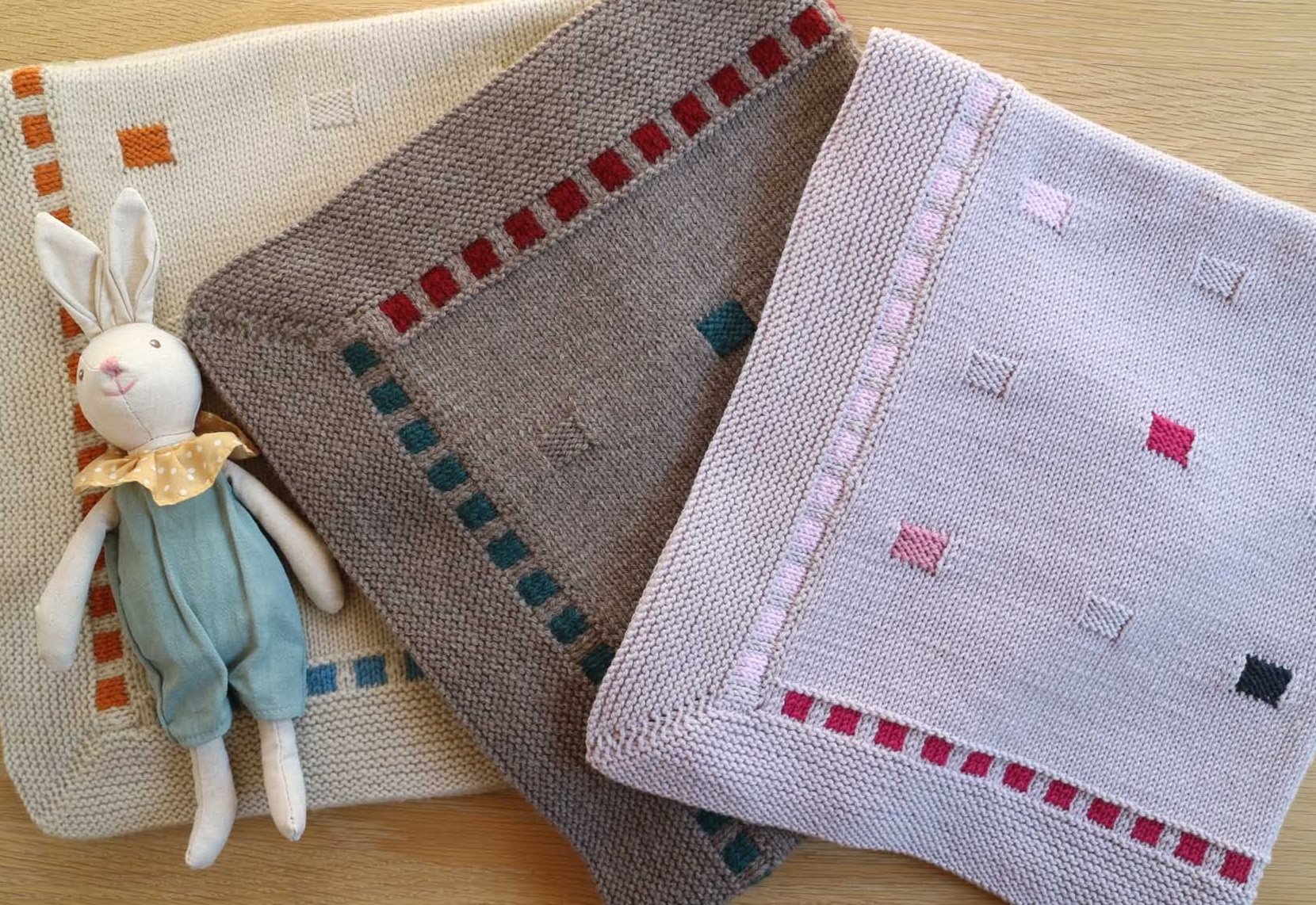 three small blocks blankets folded on table