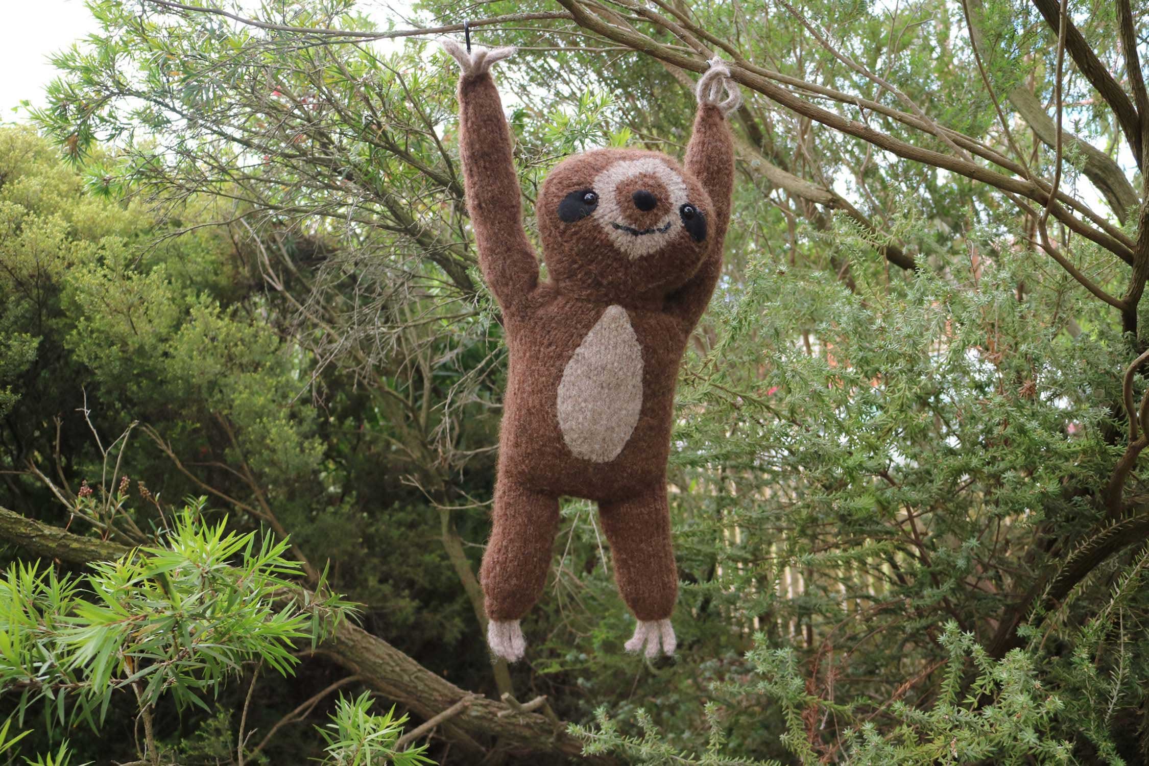 sloth knitted toy hanging from tree