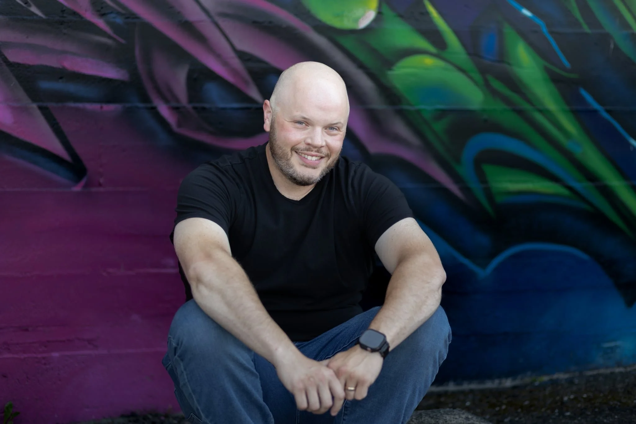 JR Berrd outside apex everett against graffiti art wall. environmental portrait