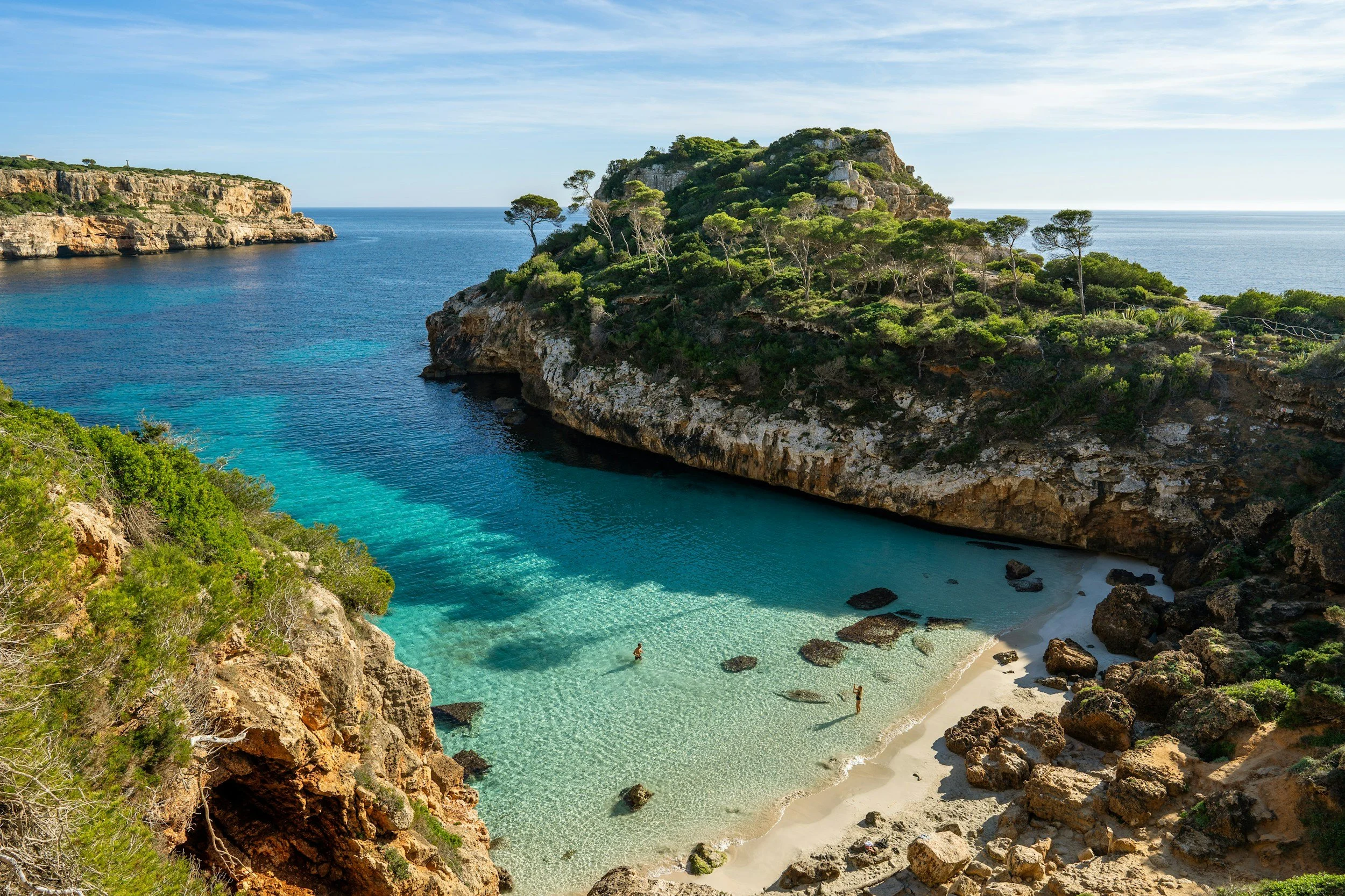 sheltered cove with clear water and rocky cliffs surrounding it