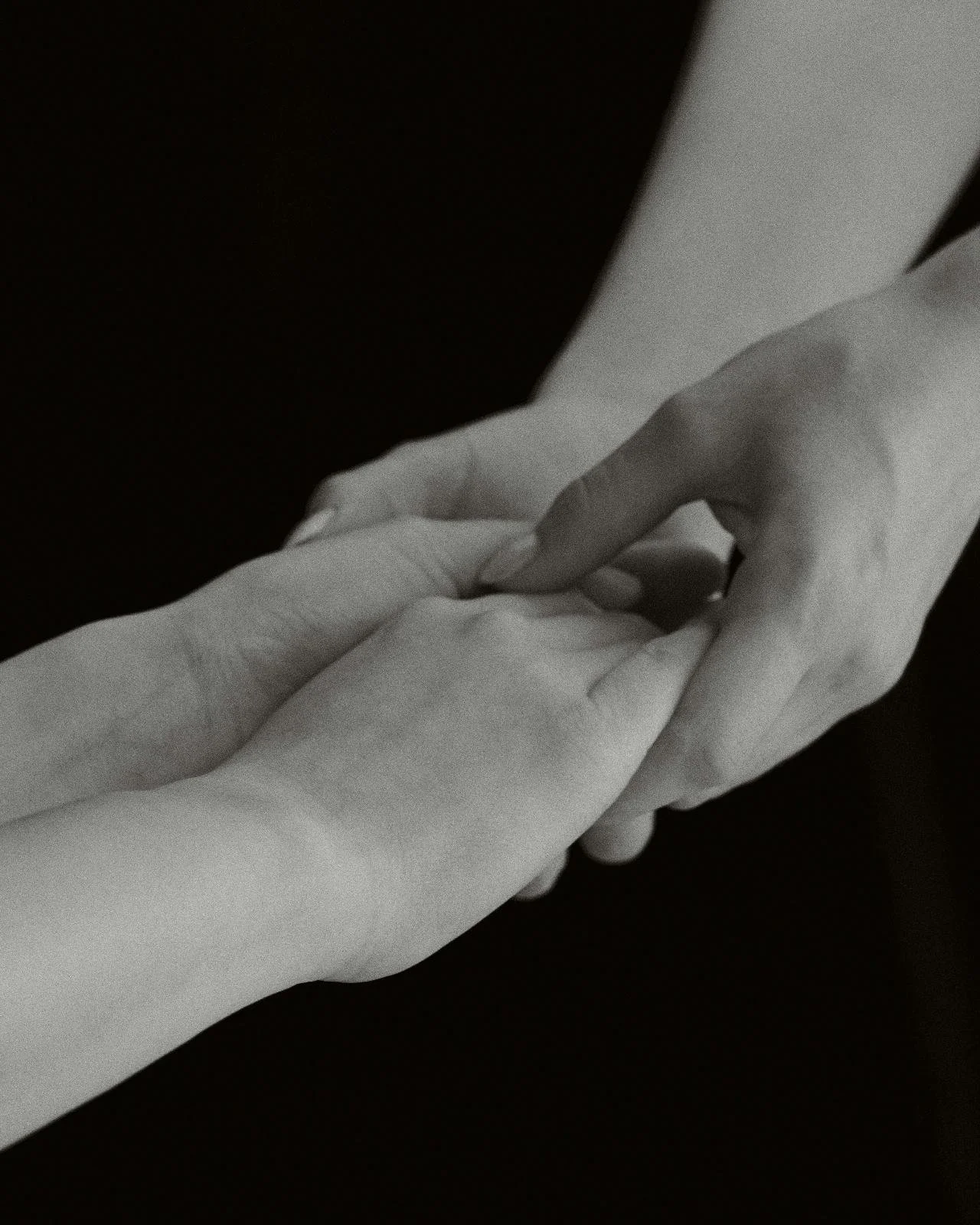 black and white photo of two people holding hands