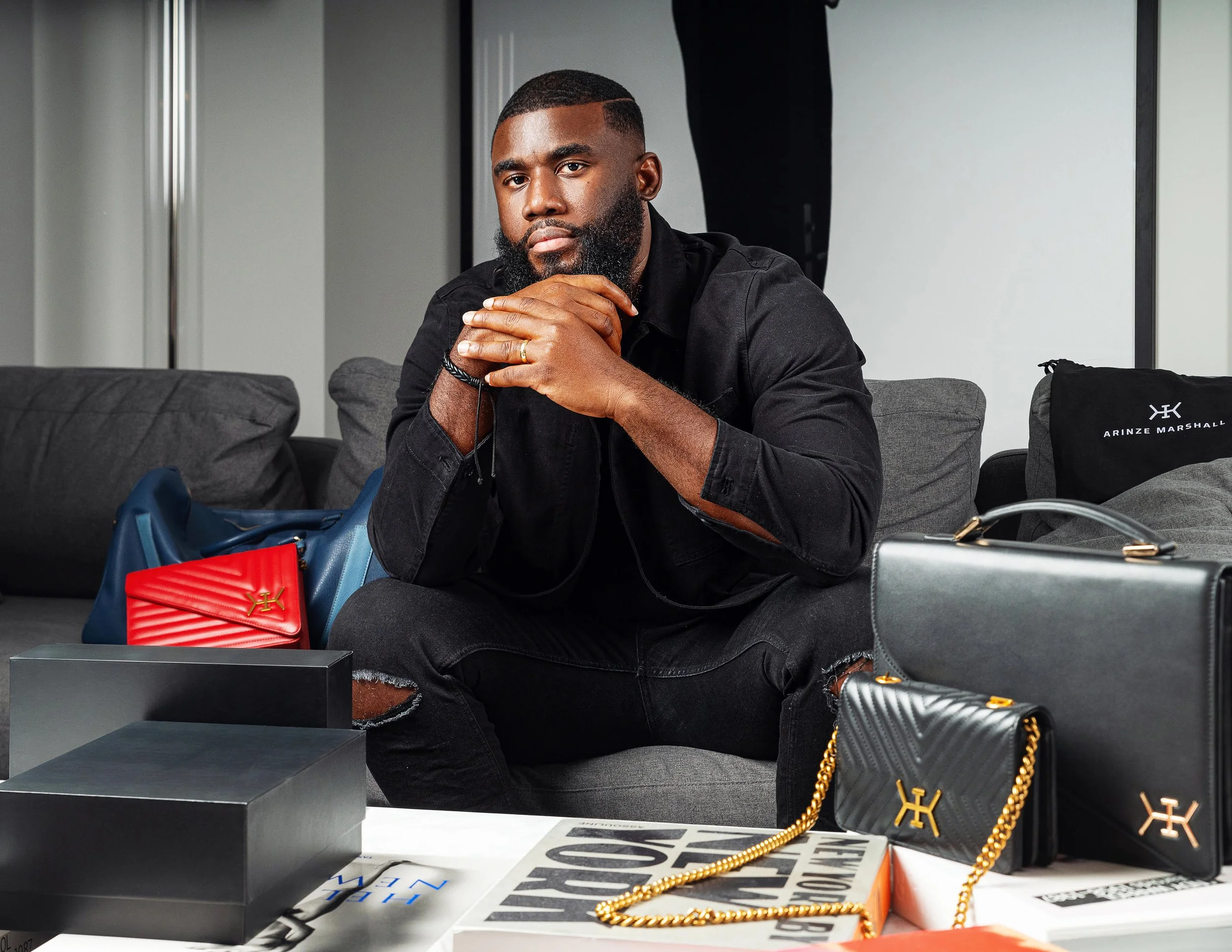 Creative Director Marshall sitting next to Arinze Marshall bags
