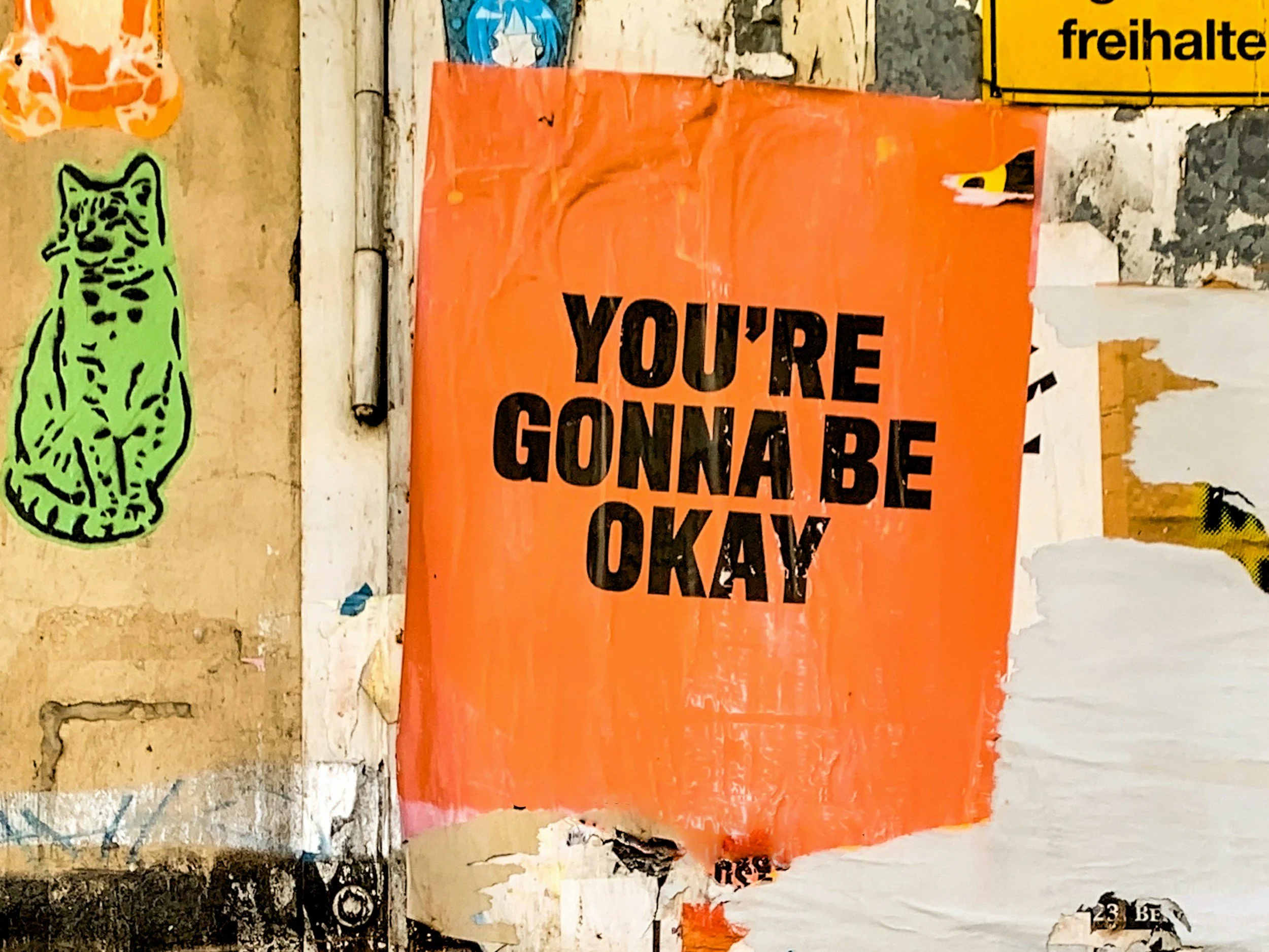 A graffiti wall with a big orange sign on the wall that says "you're gonna be okay." Trauma therapy in Philadelphia. Trauma therapists in Colorado. Trauma therapists in Philadelphia. EMDR therapy in Philadelphia. Trauma informed therapists in PA.