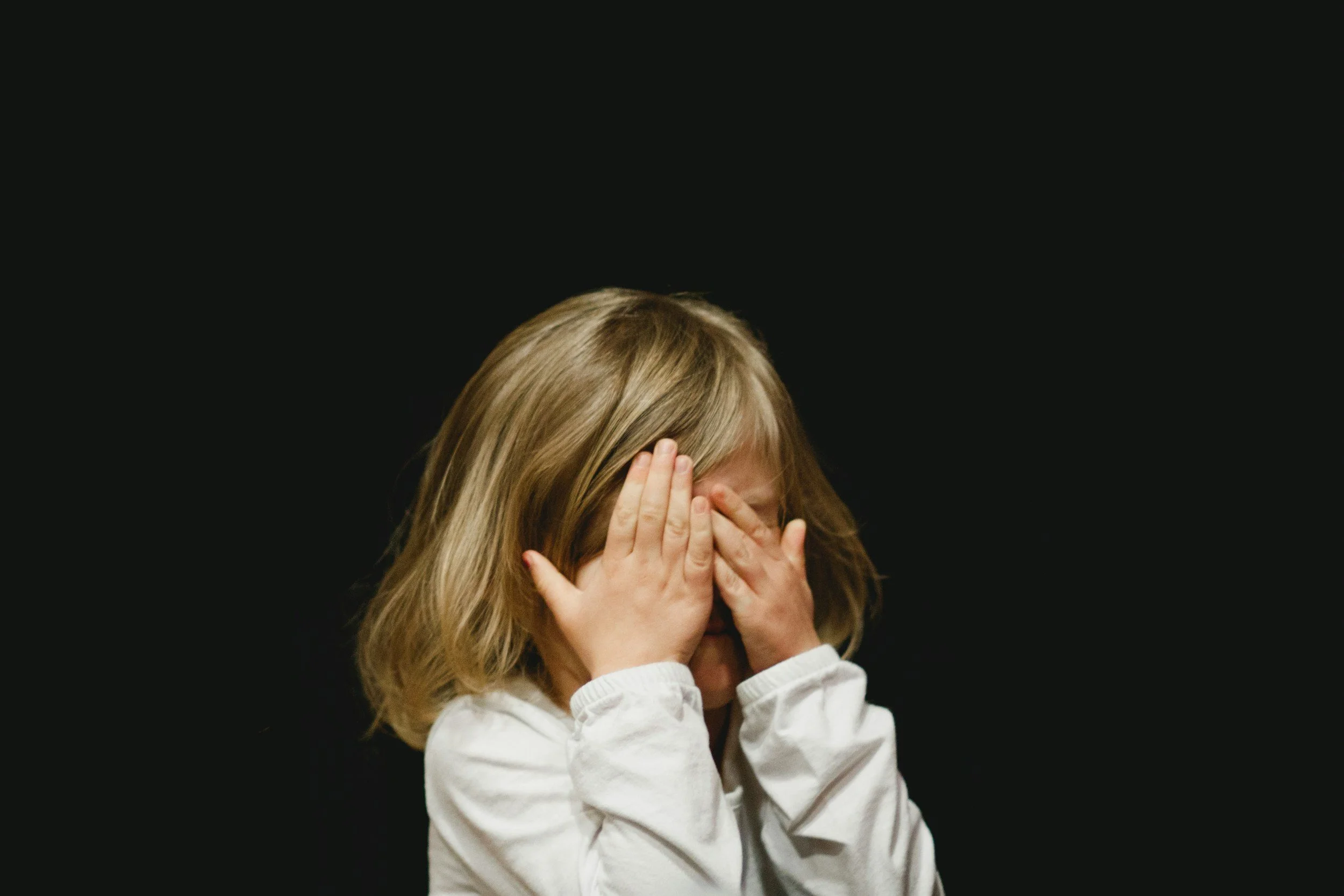 Picture of a little girl covering her face with her hands. EMDR therapy in PA. EMDR therapy in Denver, CO. Ketamine therapy in CO. Ketamine therapy in PA.
