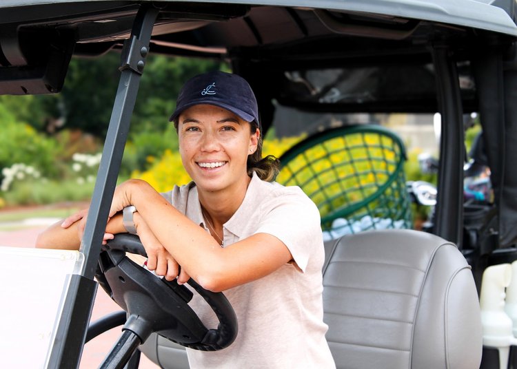 Leslie Cloots smiling in a golf cart