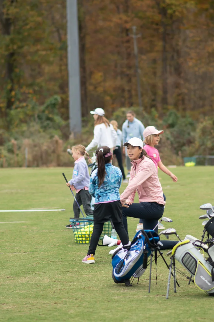 Leslie Cloots coaching a junior golfer on the practice green