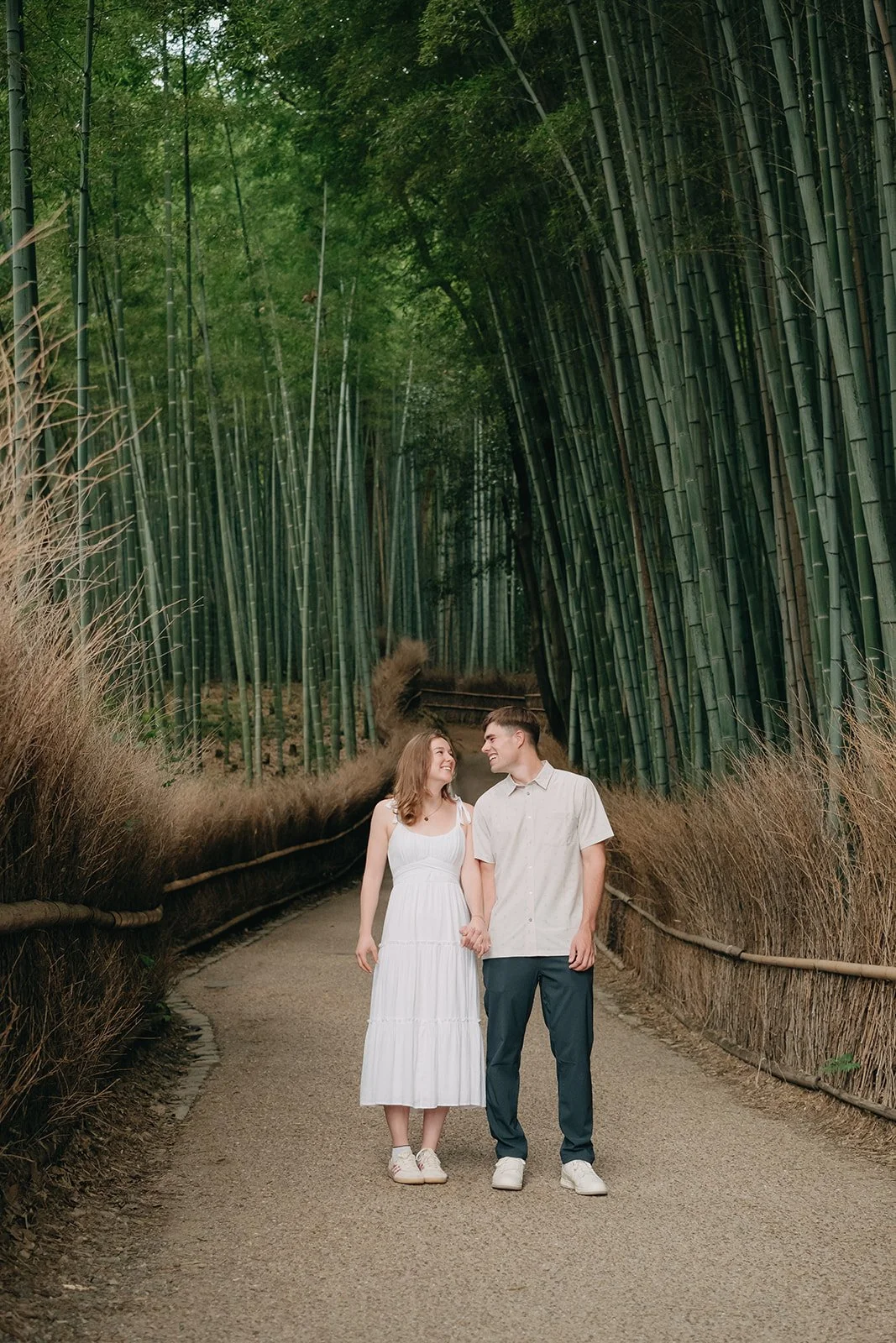 Newly engaged couple walking Arashiyama Bamboo Forest Kyoto Japan