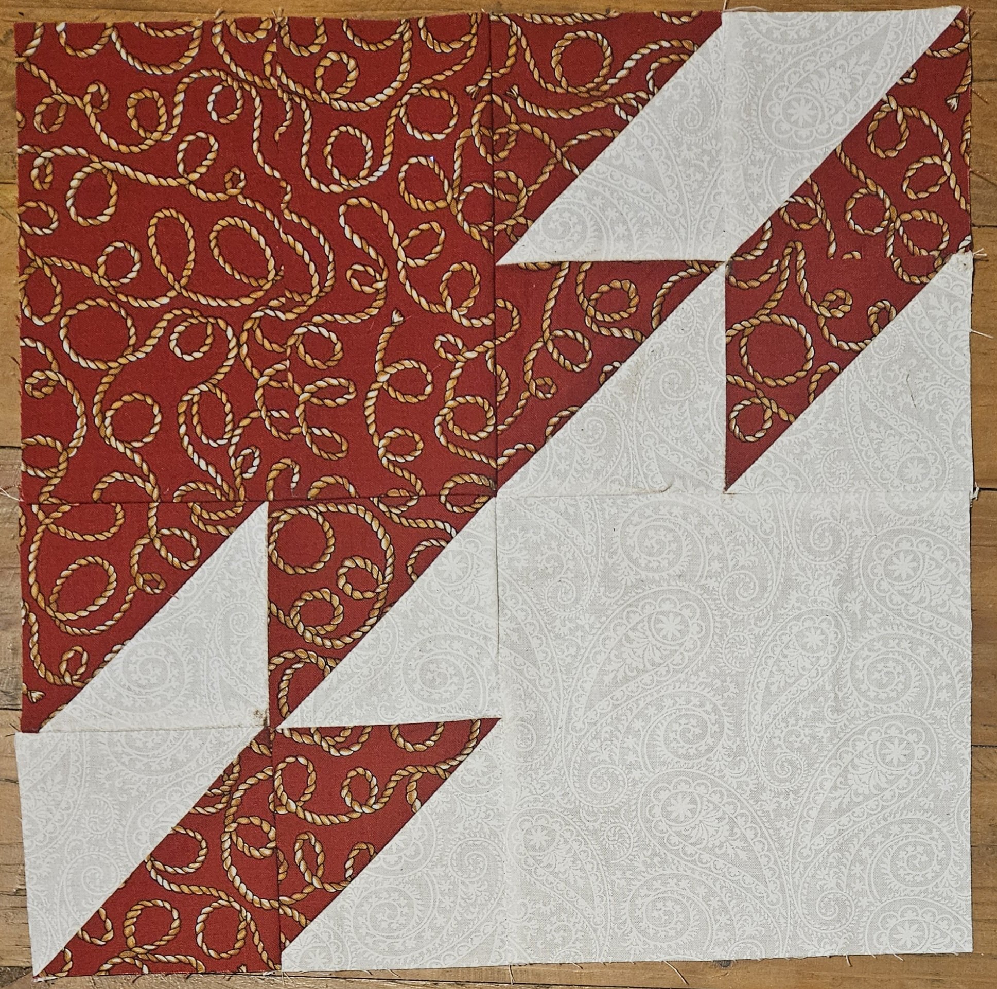 A block consisting of two shapes, not unlike cartoon fish swimming away from each other, one in red the other in white