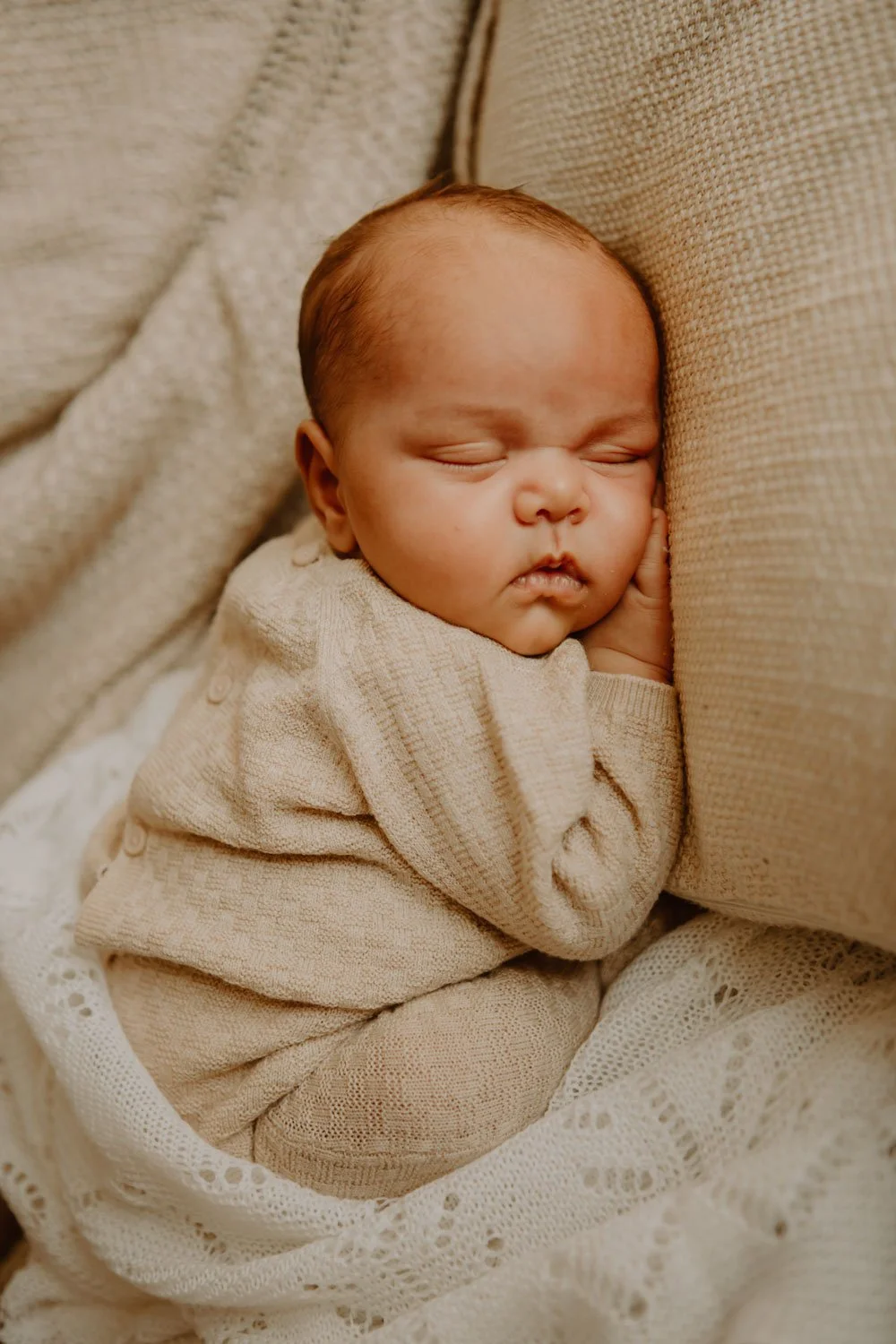 Peaceful newborn curled in sleep, captured with a calm, natural approach to London newborn photography