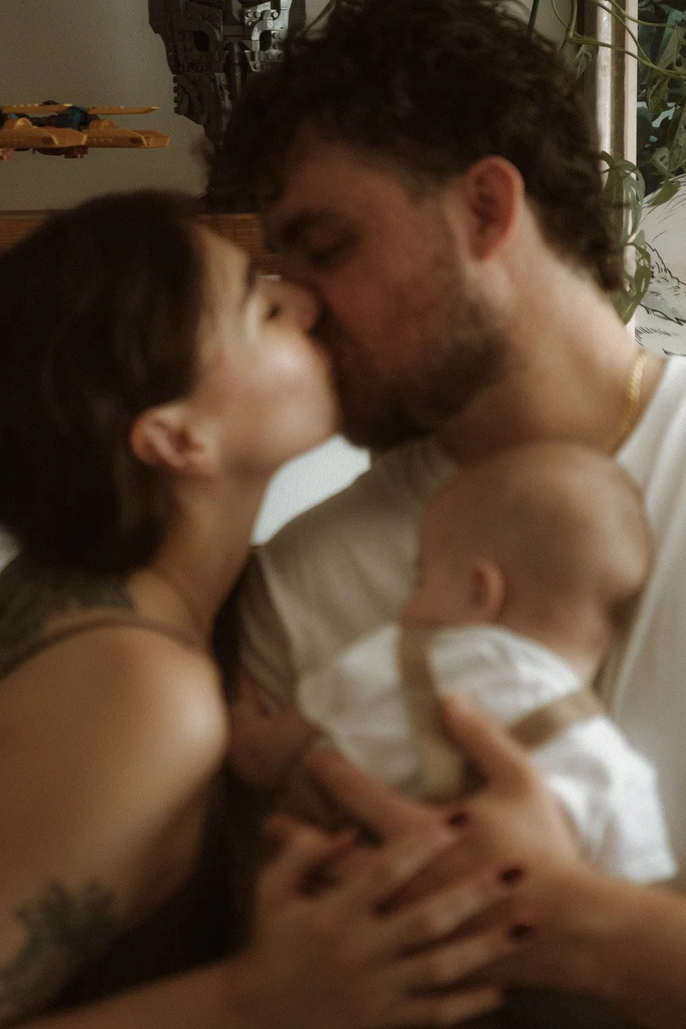 New parents sharing a quiet moment with their baby during an at-home family photography session in London.