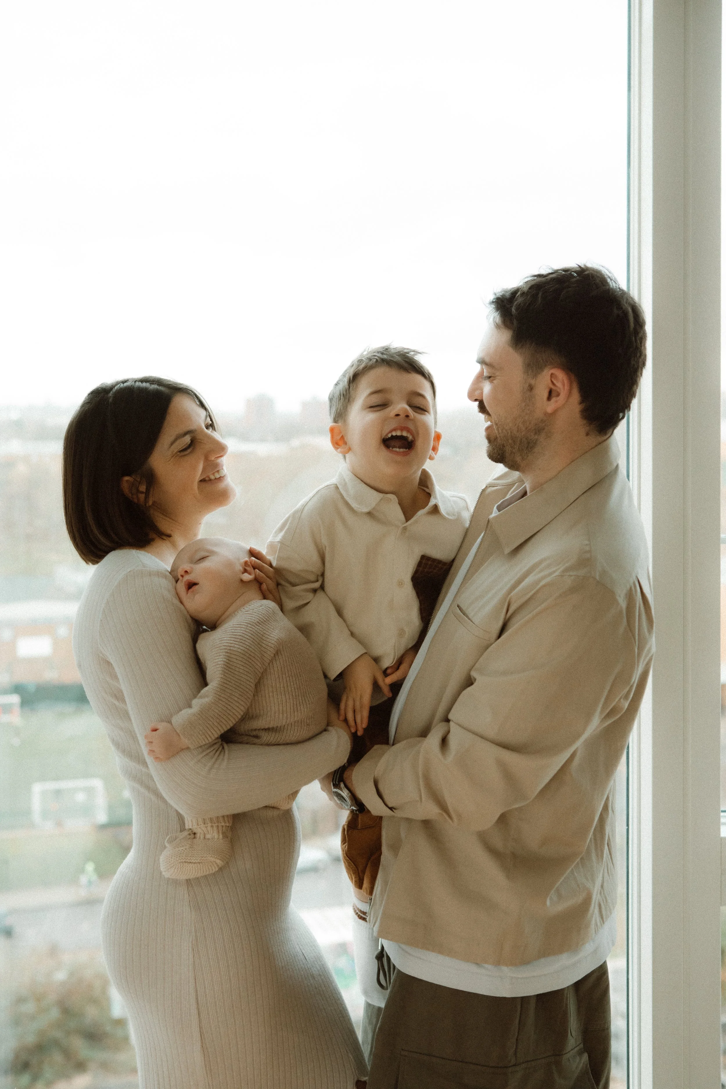 Mother  and Father with newborn baby and child during in-home family session, Southeast London