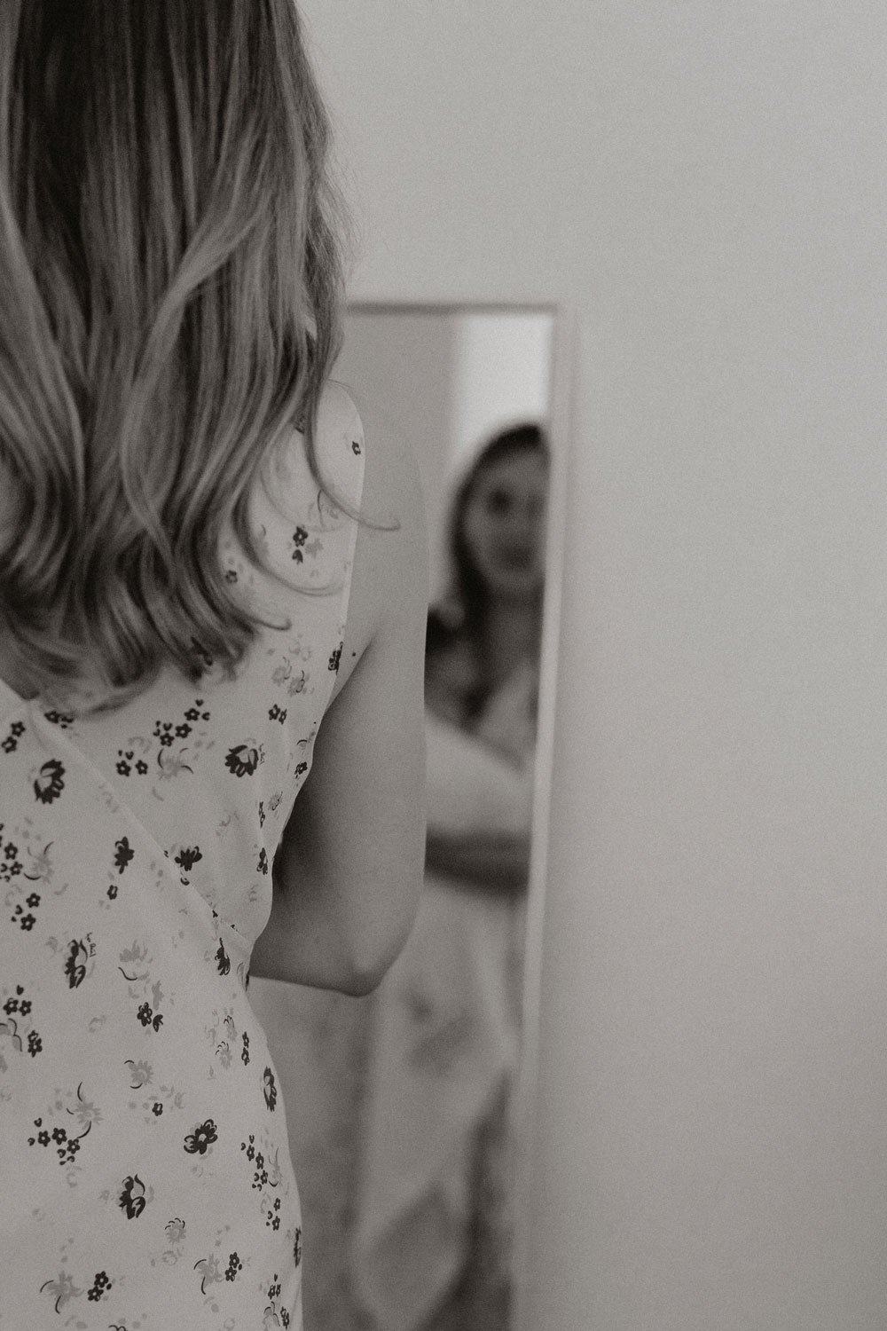 mother looking at herself in the mirror with her baby in arms