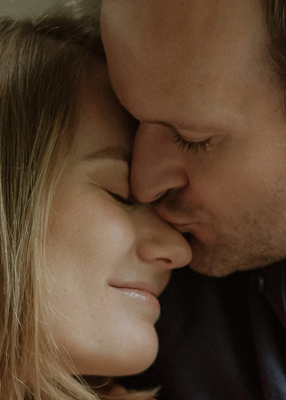 a couples faces touching embraced