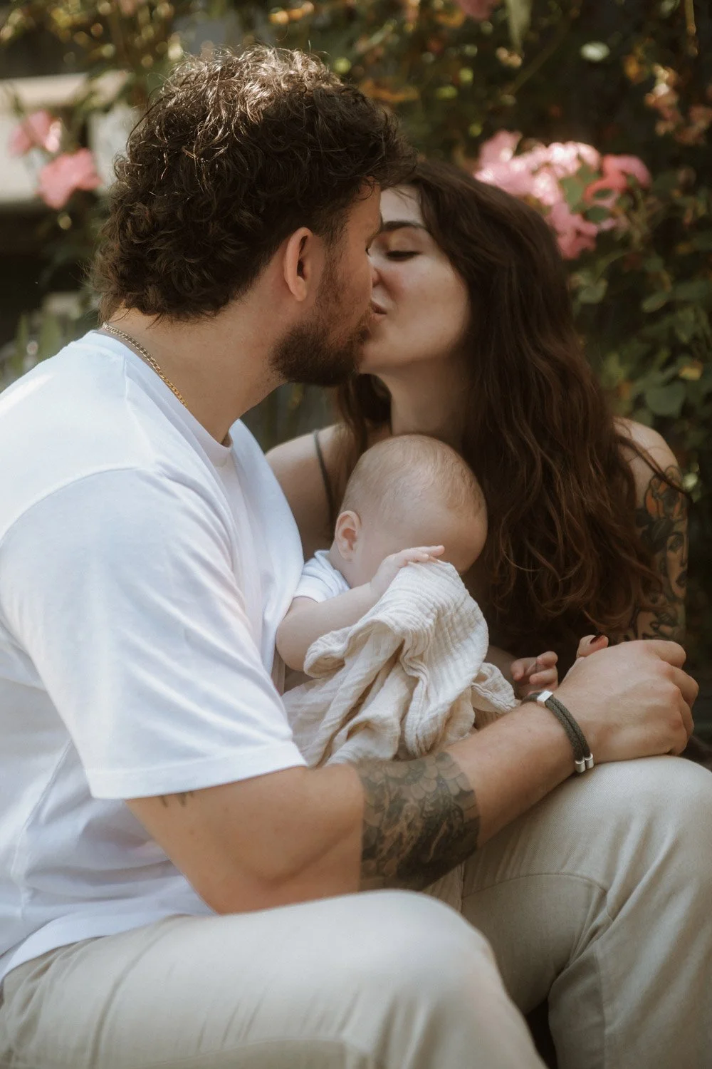 Couple kissing with their baby in arms