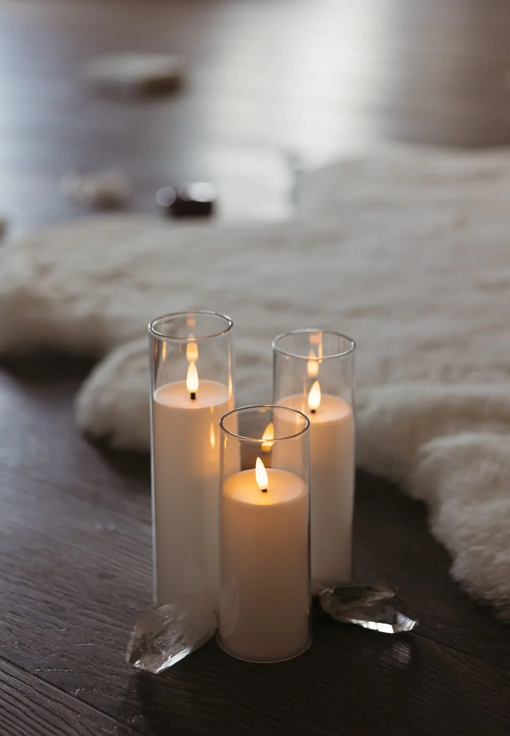 Three white candles burning in glass holders.