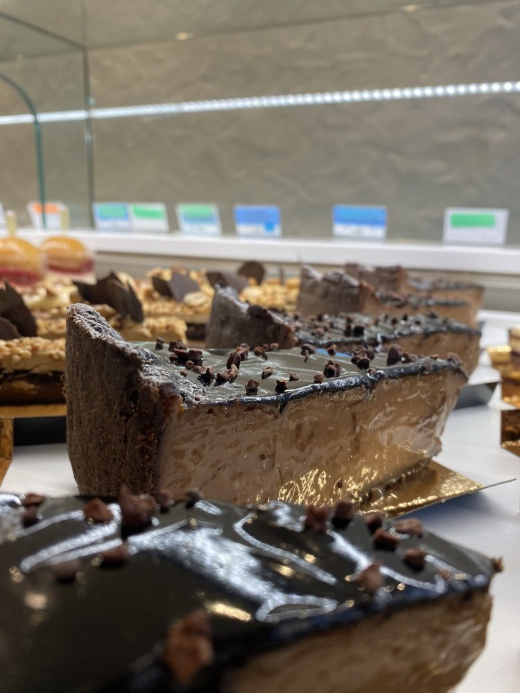 Gâteau au chocolat avec une couche de glaçage noir et des copeaux de chocolat.