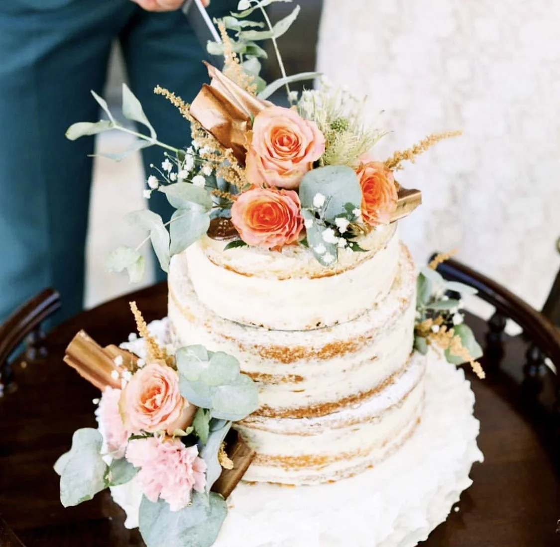 Gâteau de mariage nake avec des fleurs roses et vertes en décoration
