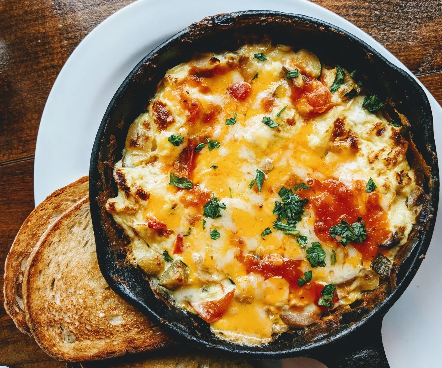 Oeuf cocotte aux légumes avec toast de pain grillé.