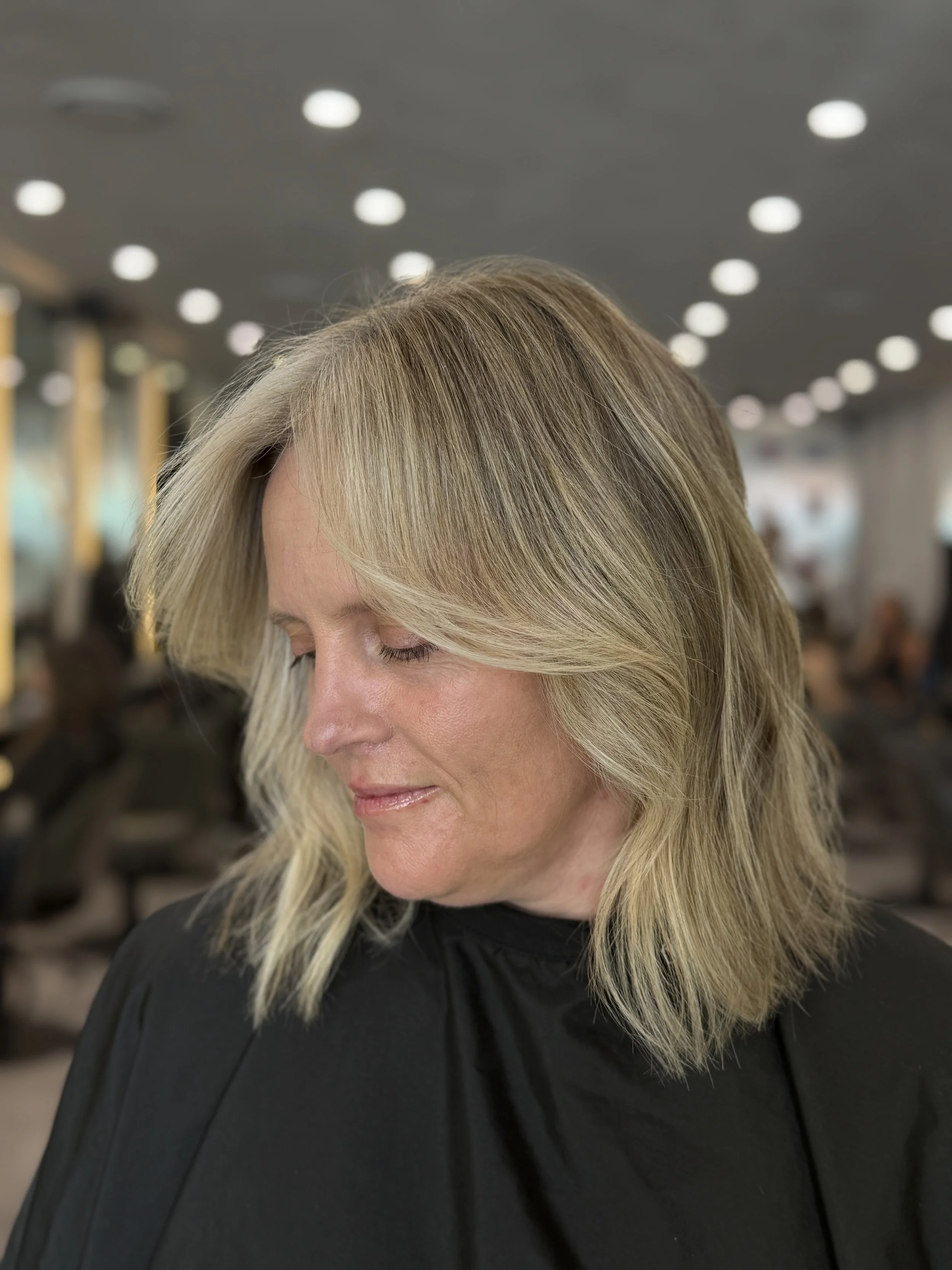 Soft blonde grey blend on shoulder-length hair, styled by Stephen William Hair in Waterlooville