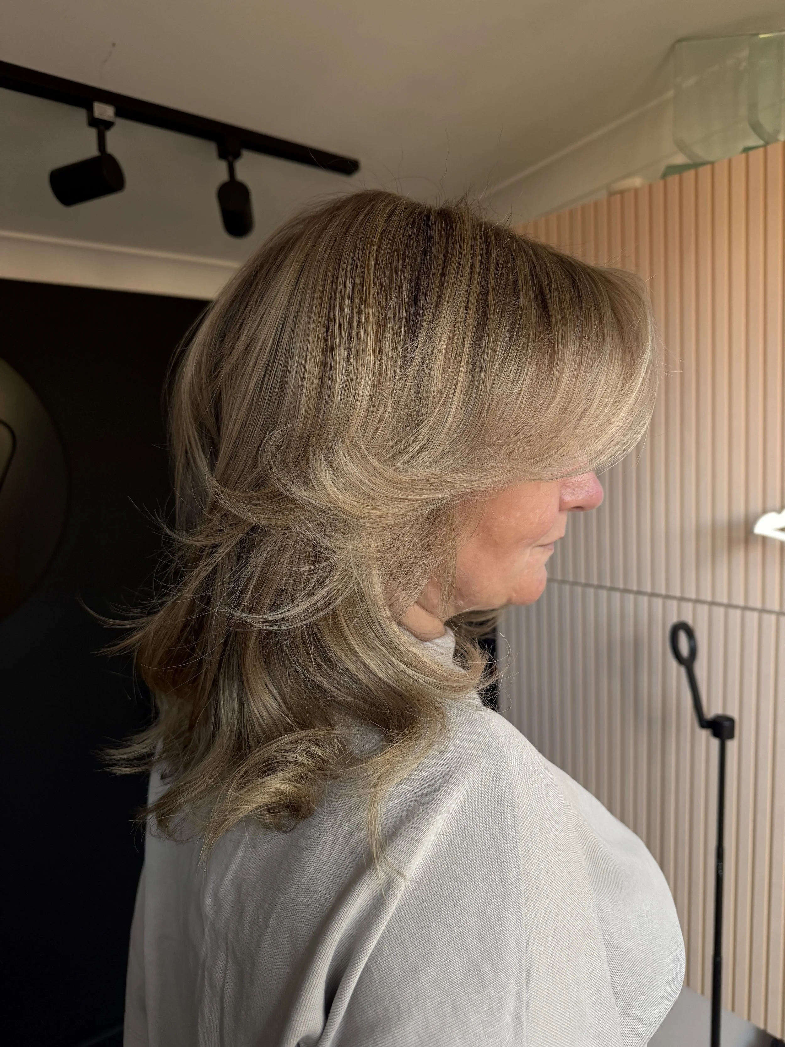 Layered ash blonde grey blend in profile at Stephen William Hair, Hampshire