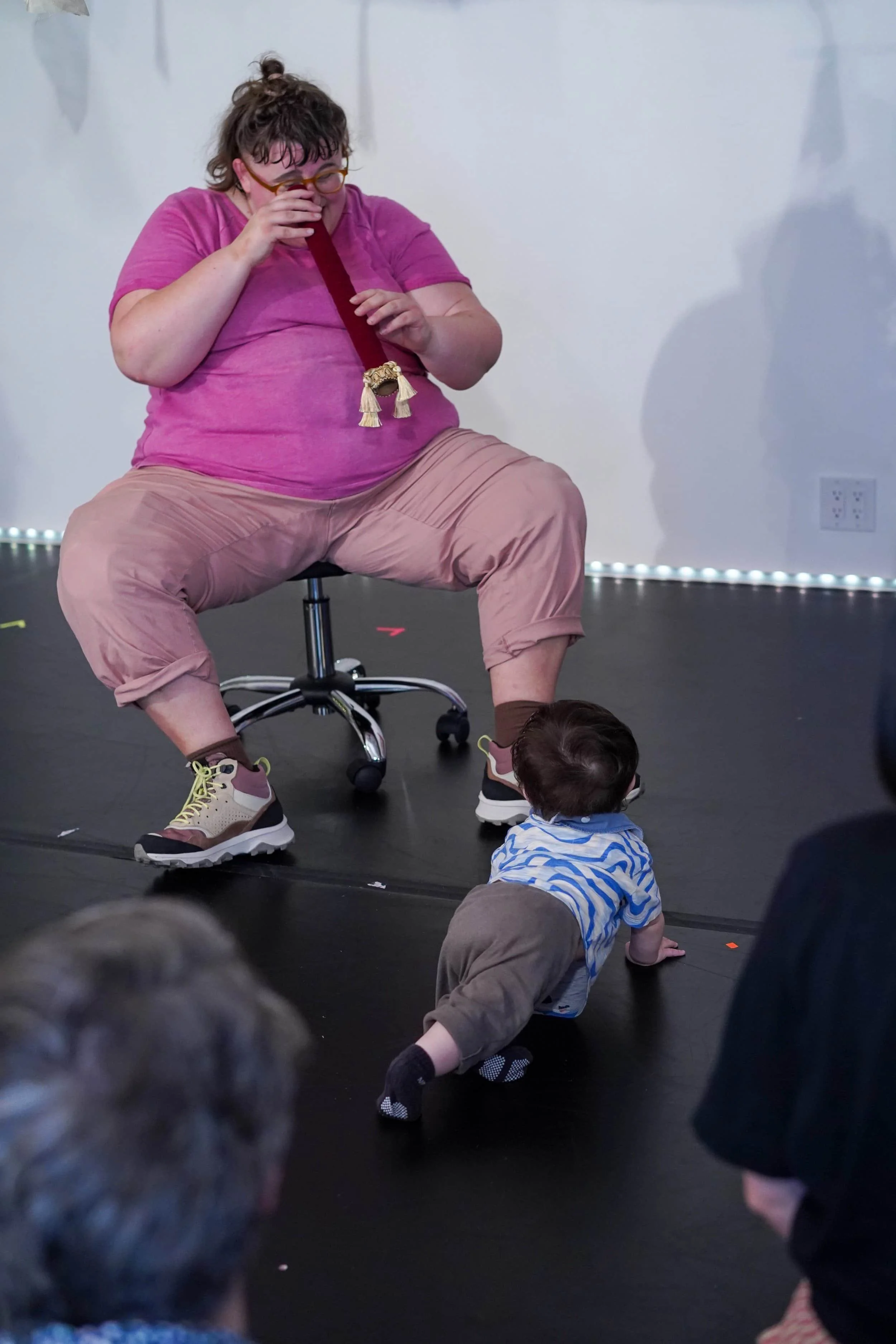Susanna performing while looking at a toddler through a small tube