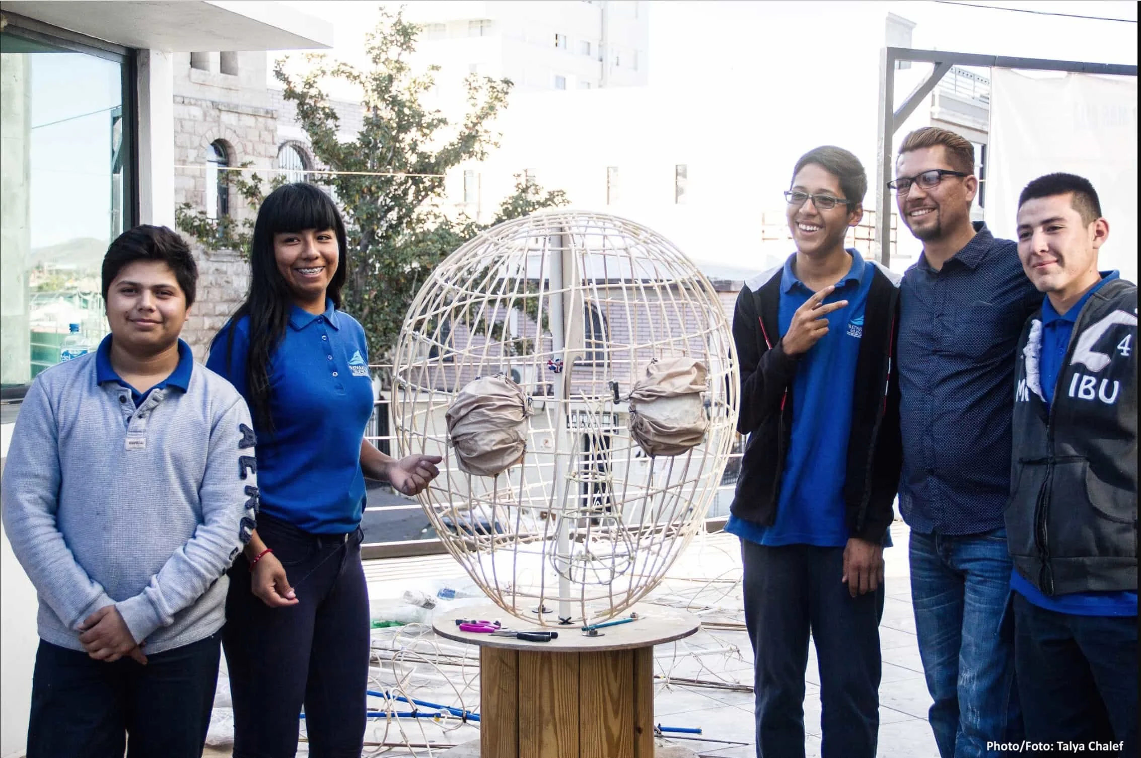 Oscar and his students in Mexico, smiling and posing with a giant puppet head they built.