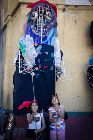 Two young girls holding a large puppet above their heads