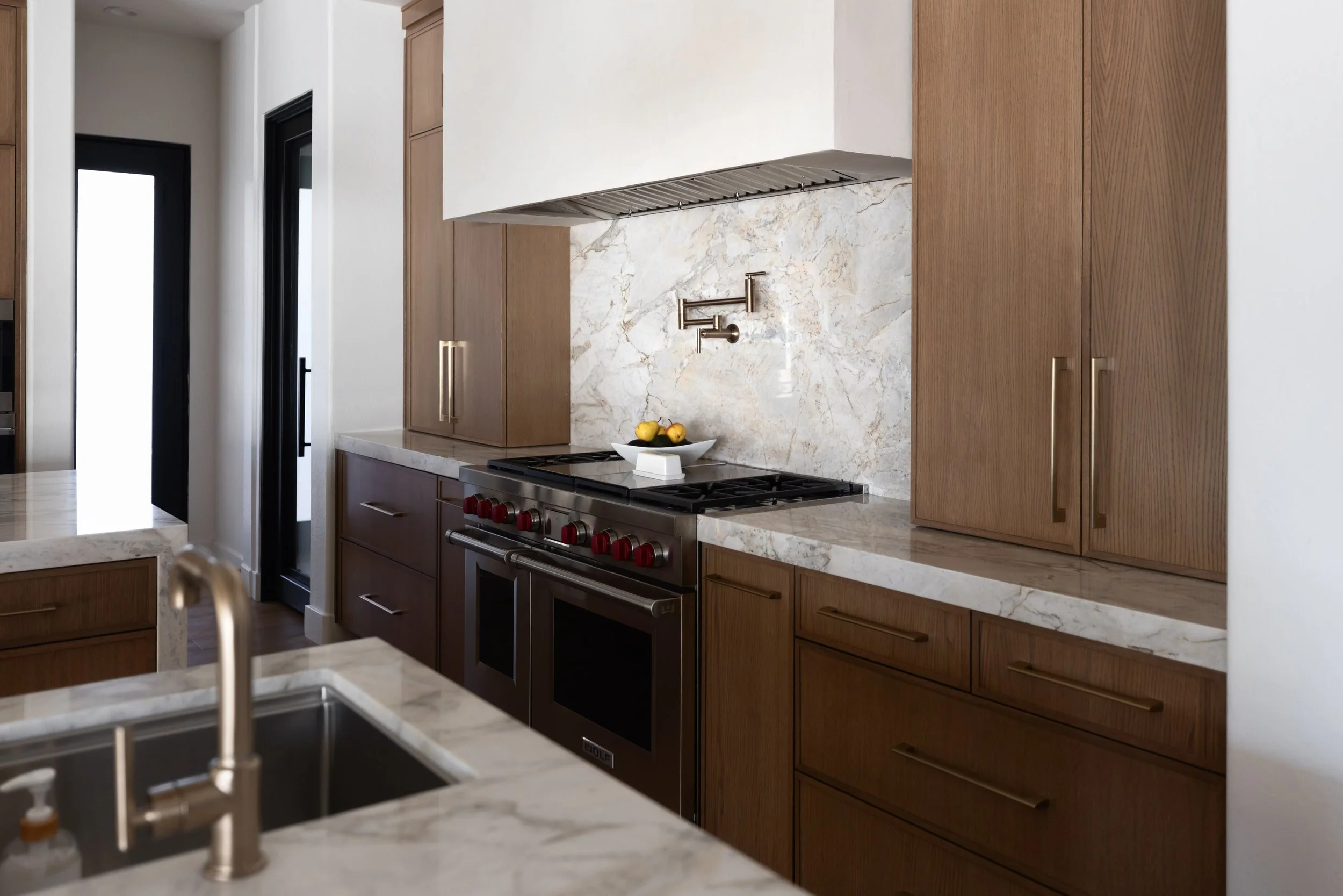 Open kitchen layout in a Phoenix home renovation designed with custom cabinetry, layered textures, and modern Southwest style.