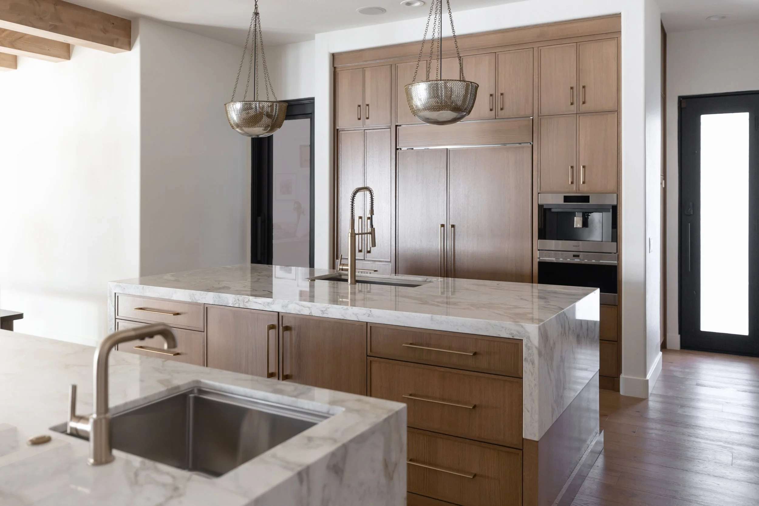 Modern kitchen island in a Phoenix kitchen remodel featuring warm wood cabinetry, natural stone surfaces, and inviting gathering space.