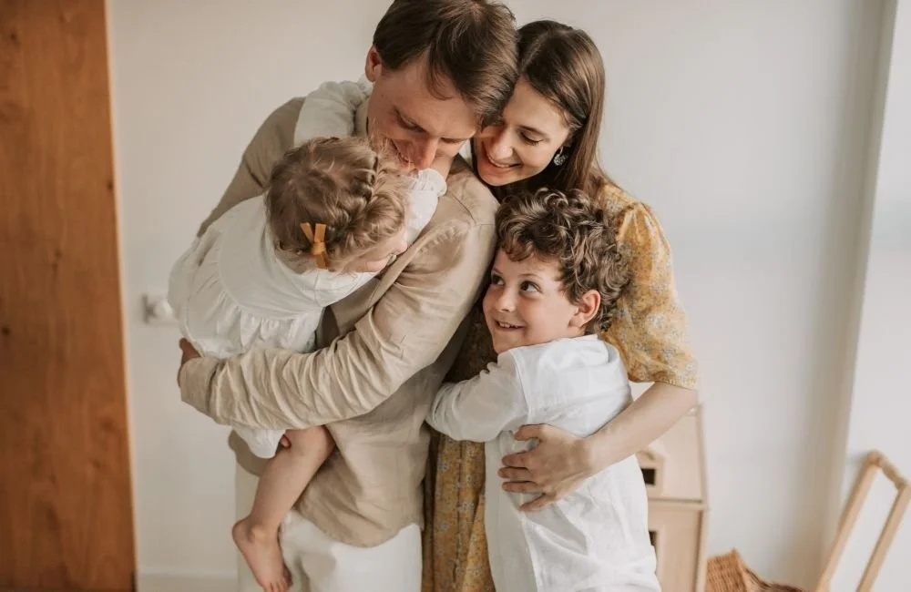 Mom, Dad, and children son and daughter hugging | Orange Seeds Montessori Centre