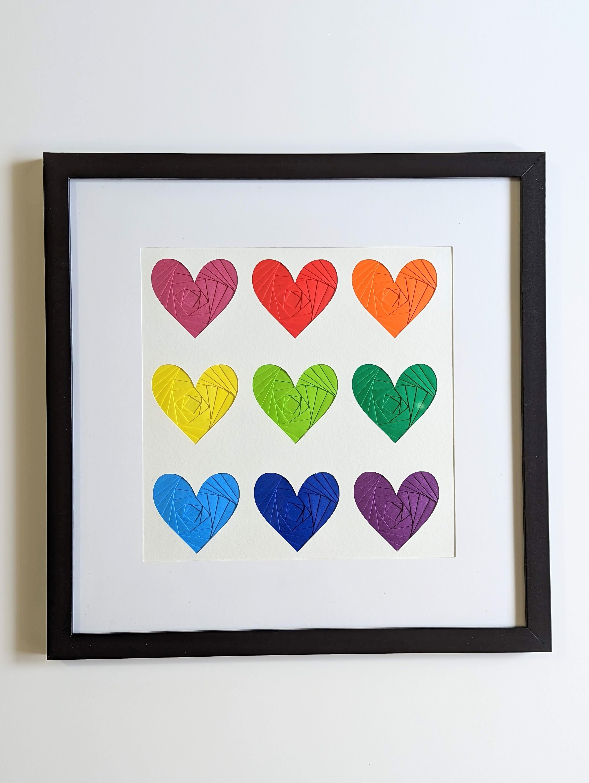 9 iris folded hearts in rainbow colors, framed