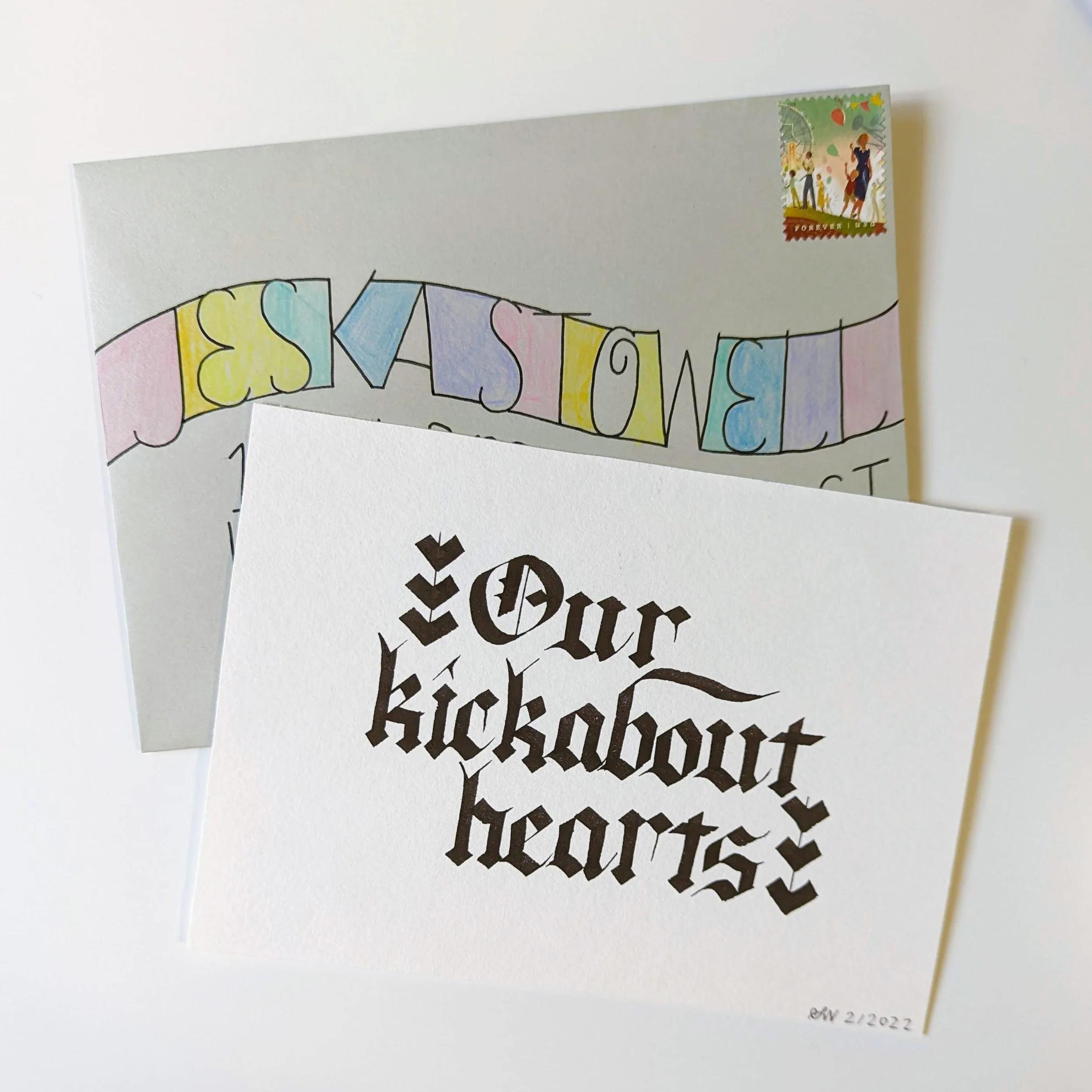 colorful monoline addressed envelope with art card reading "Our kickabout hearts" in gothic calligraphy