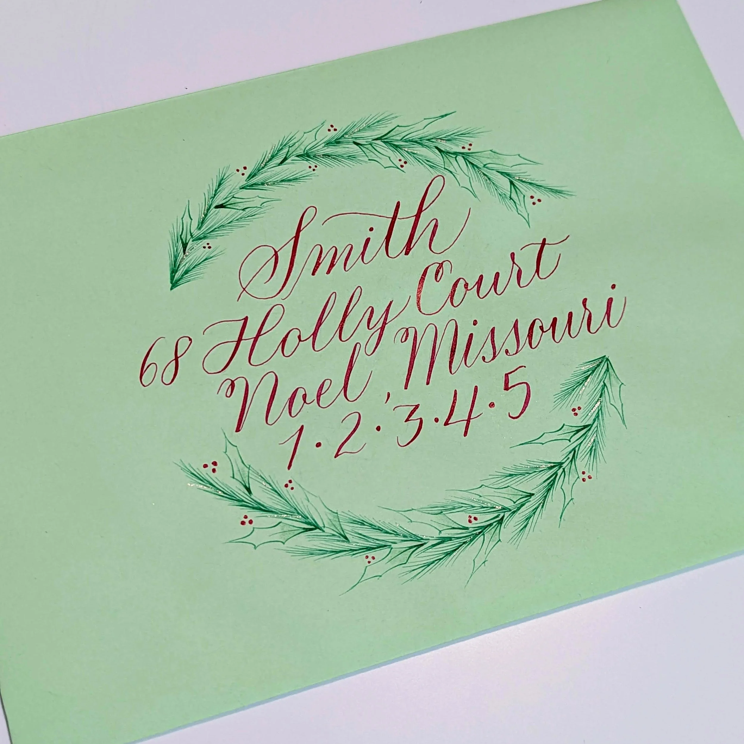 calligraphy addressed envelope with botanical holiday wreath