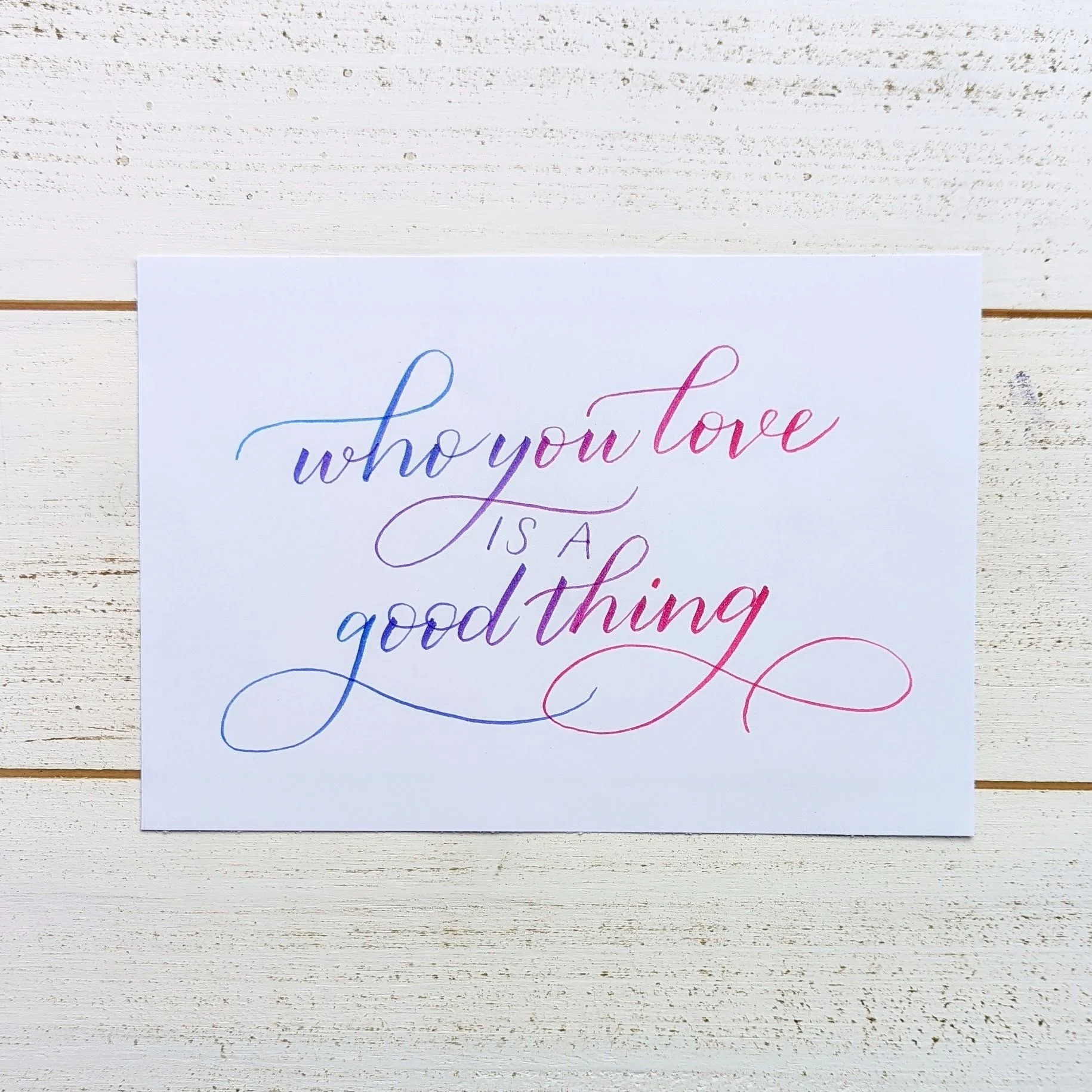 "who you love is a good thing" written in ink that shifts from pink to purple to blue