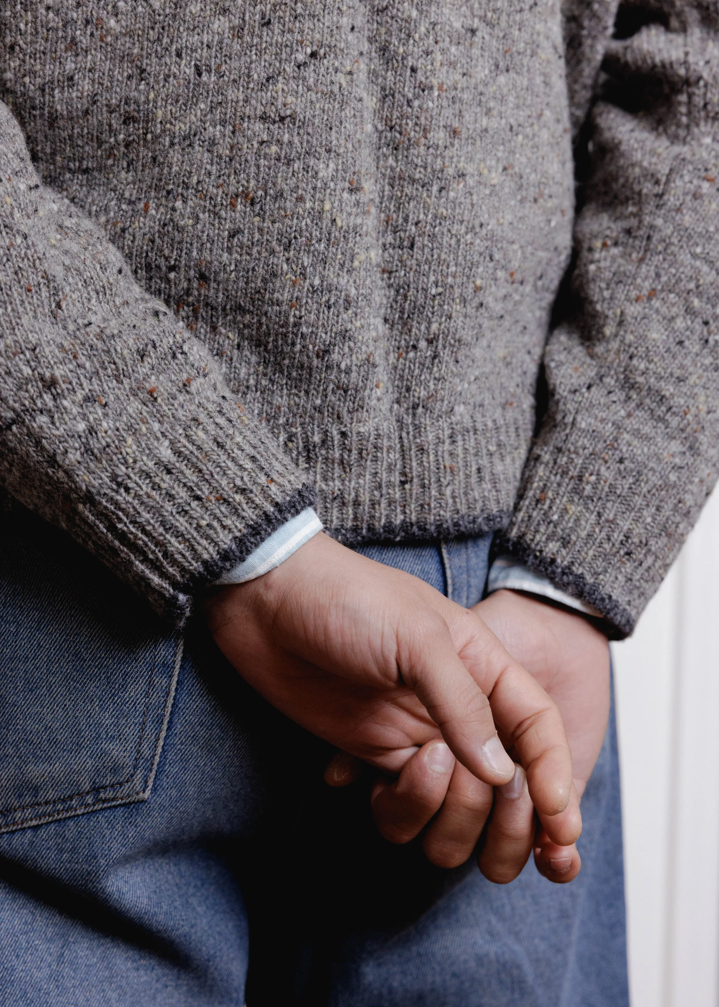 Everyday Raglan sweater in Stone, close-up of the hem and cuffs, hands clasped in front
