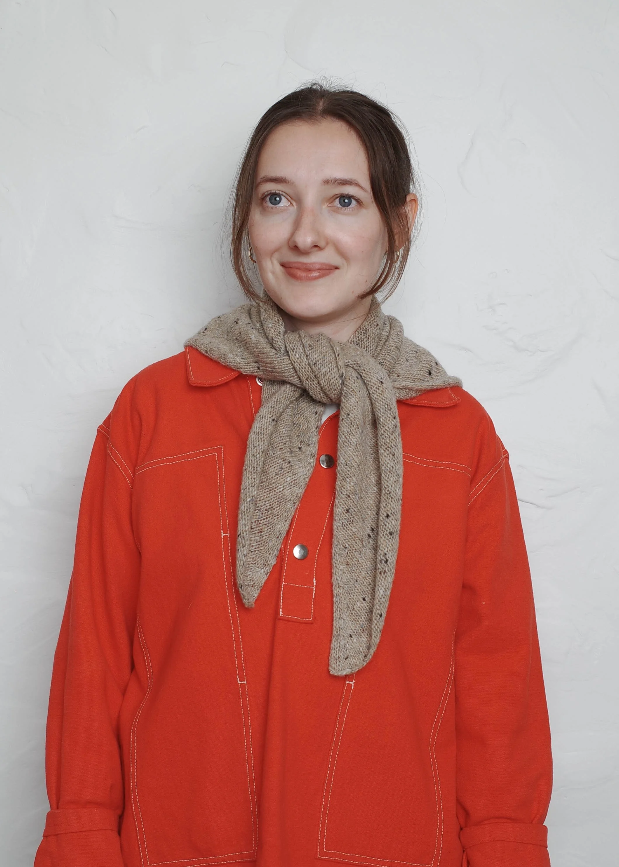 XL Knit Bandana in Oat, tied loosely over a red sweater