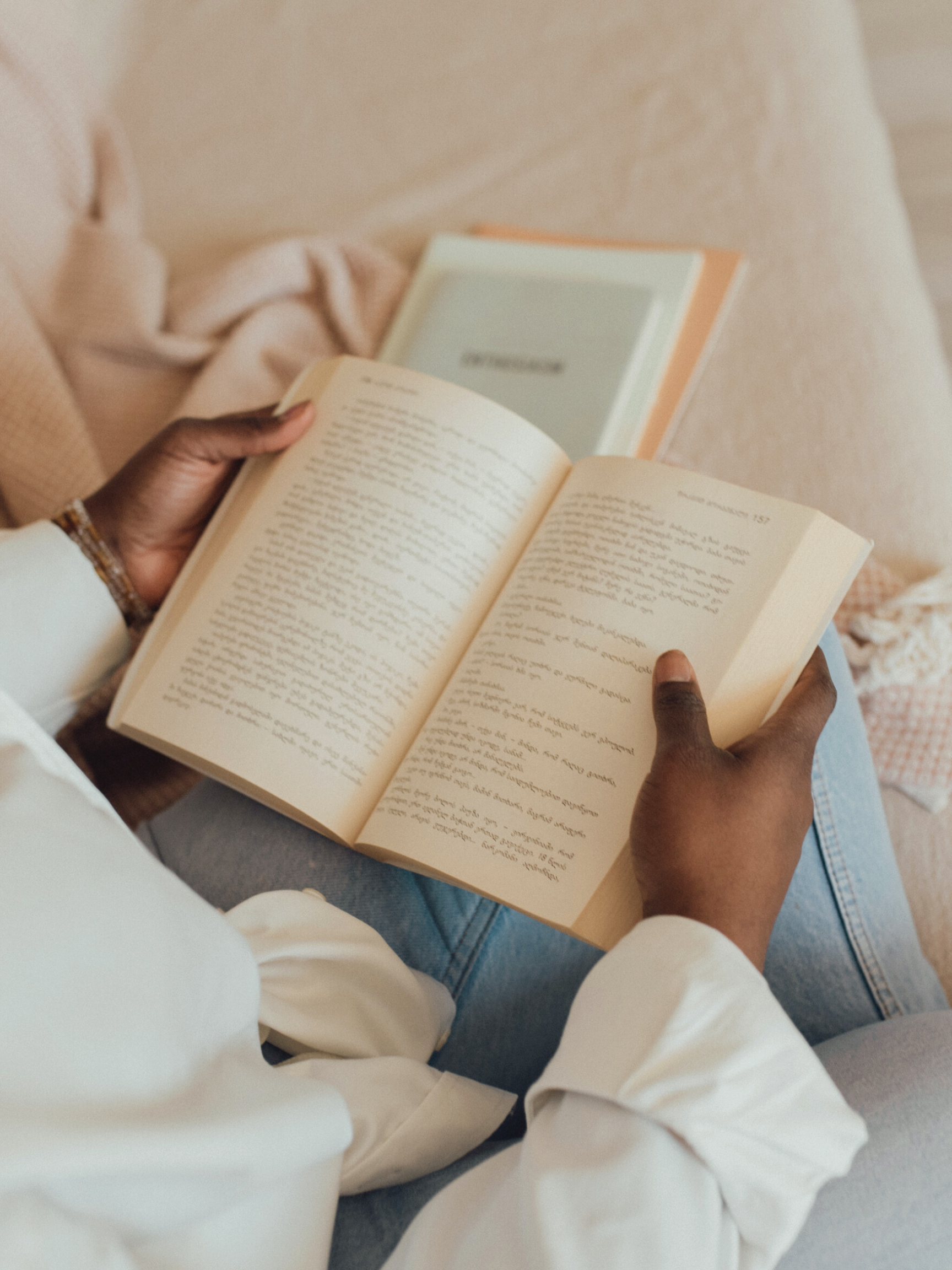 A person reads a book in a cozy setting, reflecting the continuous learning encouraged in supervision. Clinical consultation with an AAMFT approved supervisor in Washington helps deepen your professional knowledge.