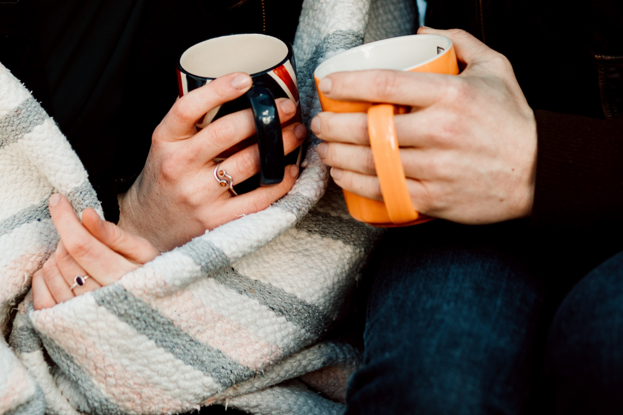 A close-up of two people holding warm mugs under a blanket, showing a moment of shared comfort. Learn how to therapist relationship anxiety with dating therapy in Portland, Oregon, to find that connection. We serve zip code 97229.