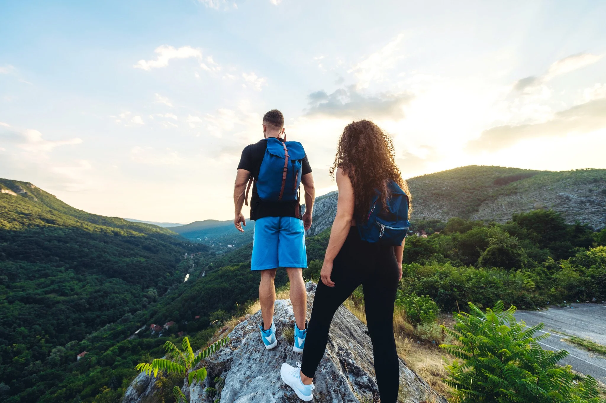 Two individuals standing on top of a mountain top while hiking. If you are feeling burnt-out at work, burnout therapy in Seattle, WA can help you recover. Learn more about therapy here.