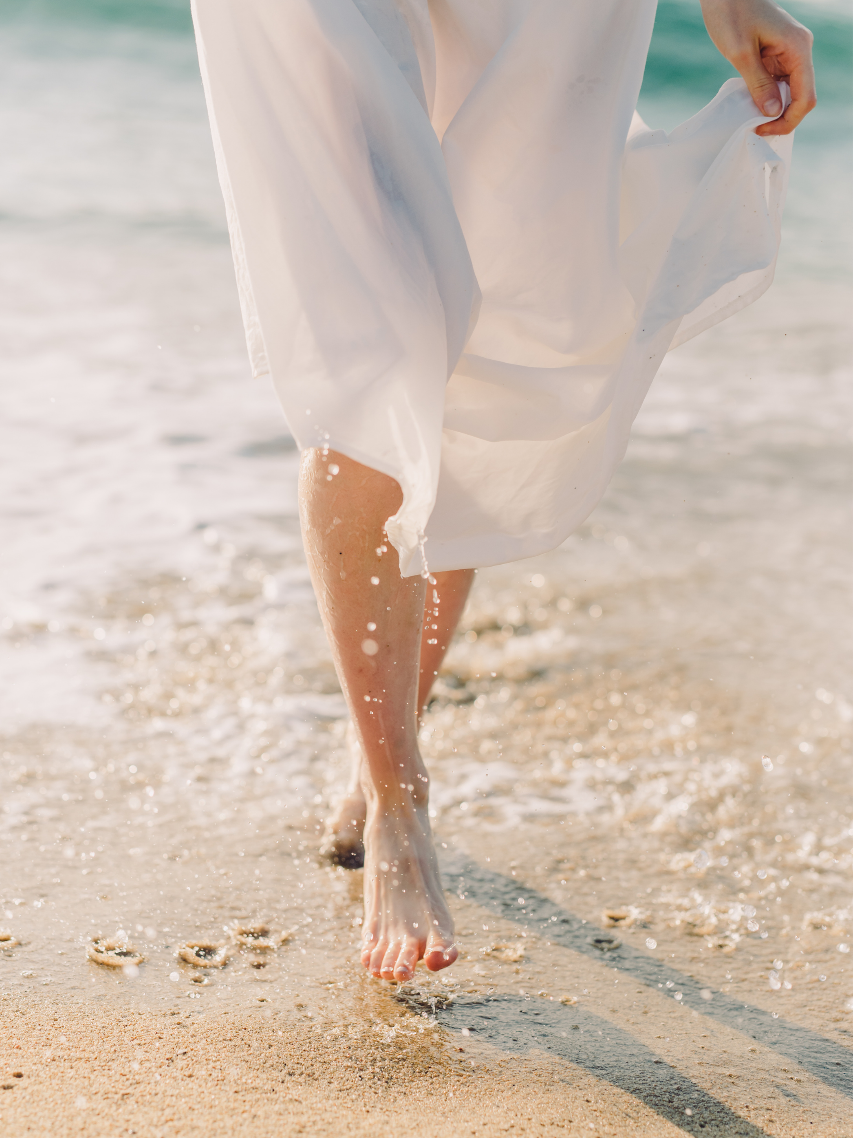 A person walks barefoot on the beach in a flowing white dress, symbolizing the clarity gained through professional guidance. Clinical consultation with an AAMFT approved supervisor in Oregon can support your practice's growth.