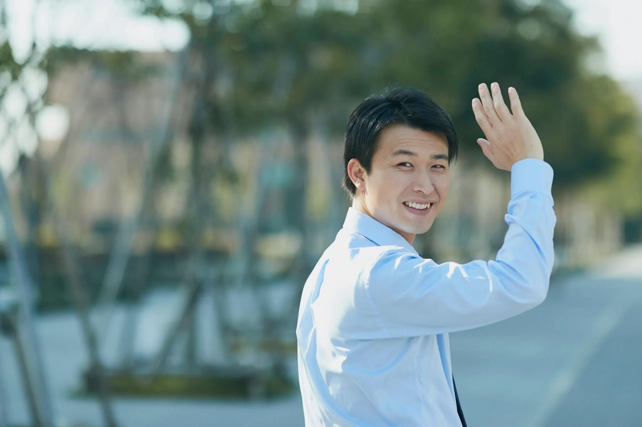 An Asian american professional waving outside. If workplace burnout is affecting your life, consider reaching out to a therapist in Seattle, WA. Learn more about workplace stress therapy here.