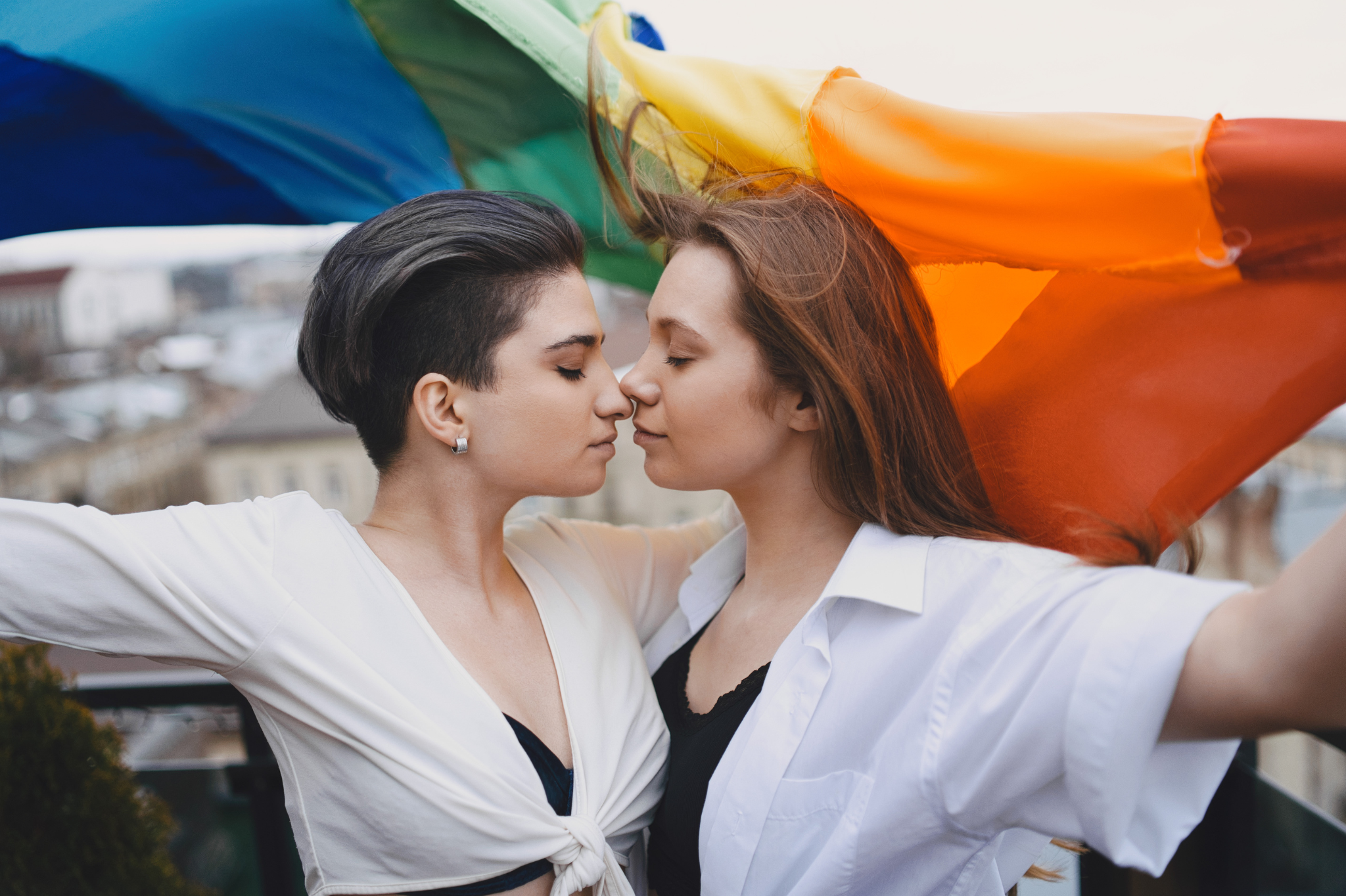 A young lesbian couple embracing under a rainbow flag, a picture of love and acceptance. Learn how to therapist relationship anxiety with dating therapy in Portland, Oregon to build secure connections. We proudly serve zip codes 97214 and 97210.