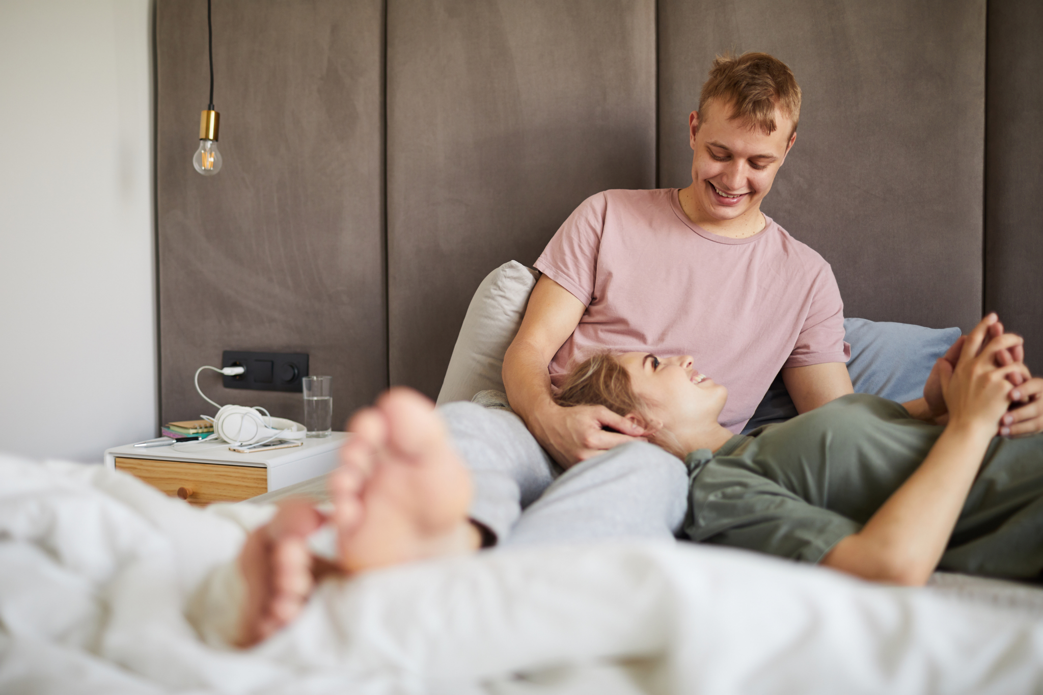 A cozy bedroom scene with one person lying on another's lap, sharing a warm and intimate moment. Perfect for illustrating connection, attachment styles, and couples counseling in Portland, Oregon, near zip codes 97035 and 97229