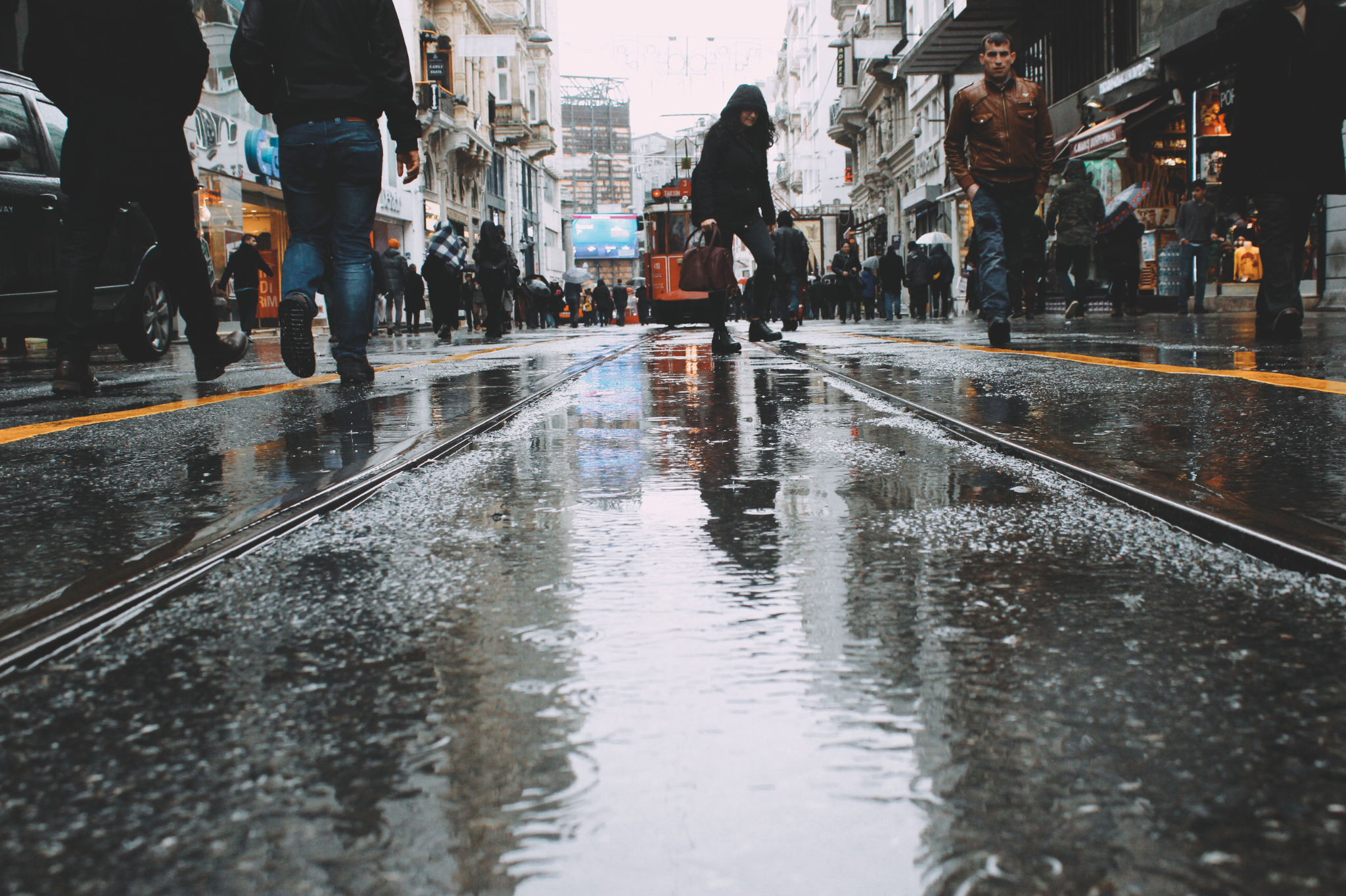 A wet, busy city street with pedestrians, representing the daily commute that can cause workplace stress and lead to burnout. Stress management services are available in Seattle and Bellevue, Washington.  98052, 98704, 98040, 98039, and 98077.