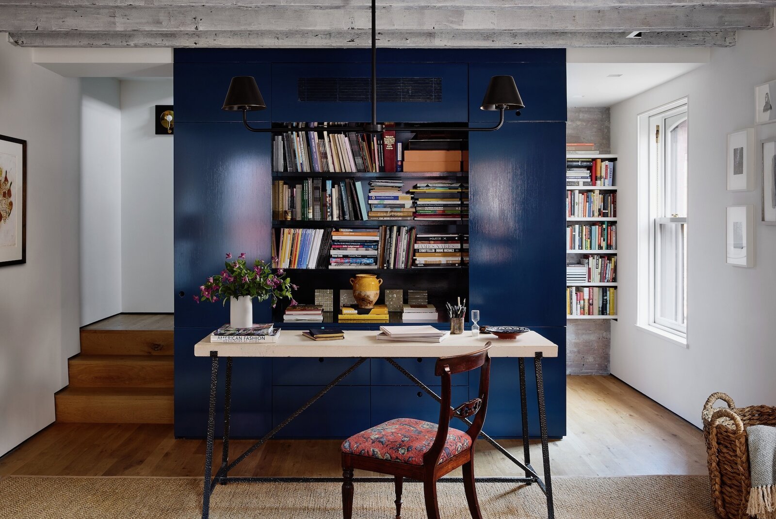  Priscilla and McBride initially discussed the office core being an actual desk that could be closed, but opted for this setup so she could sit with her back to the books and look out the window. The double arm chandelier from The Urban Electric Co. 