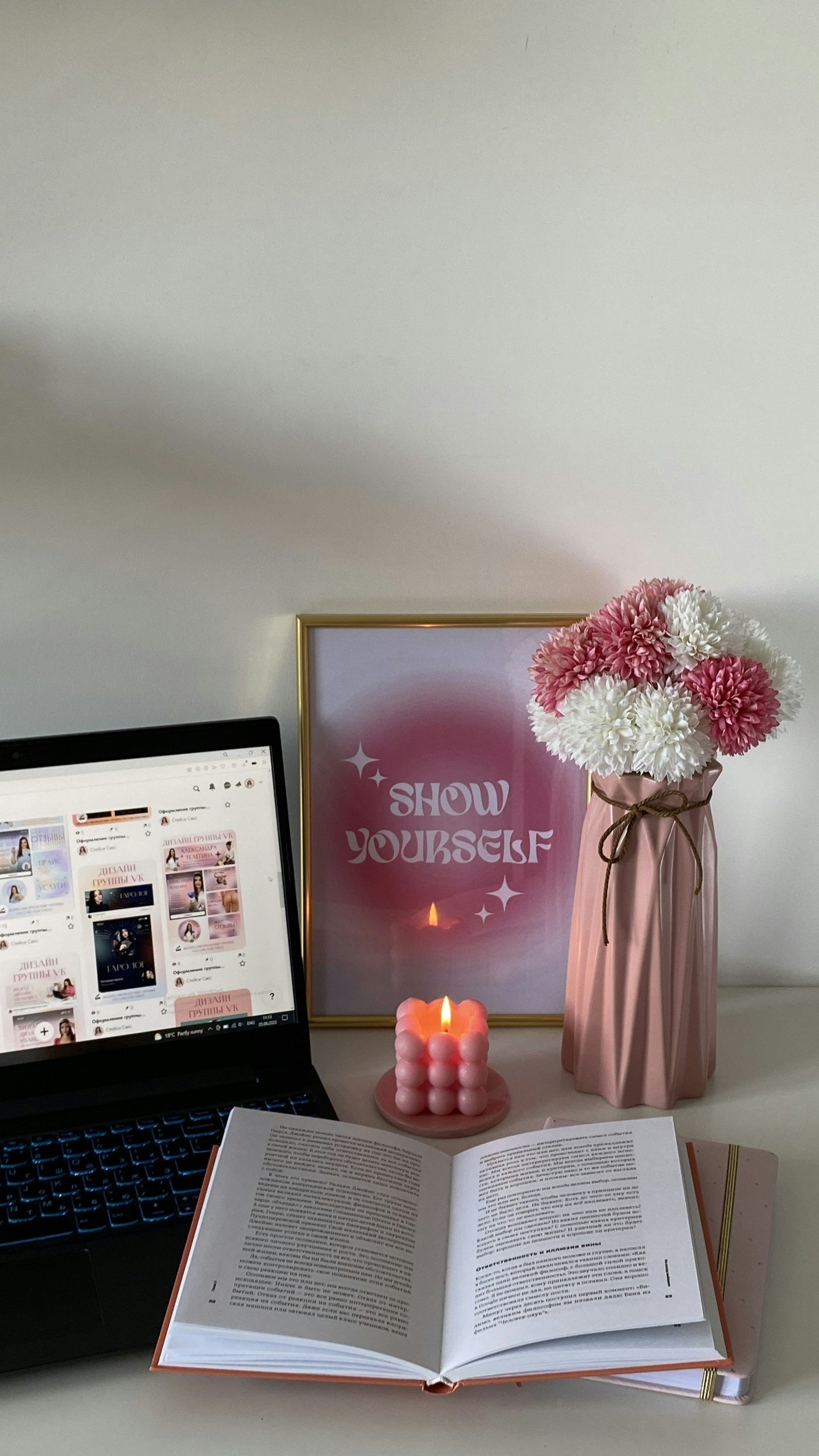 Computer with flowers, candle and show yourself poster for why a beautiful website alone doesn't convert.