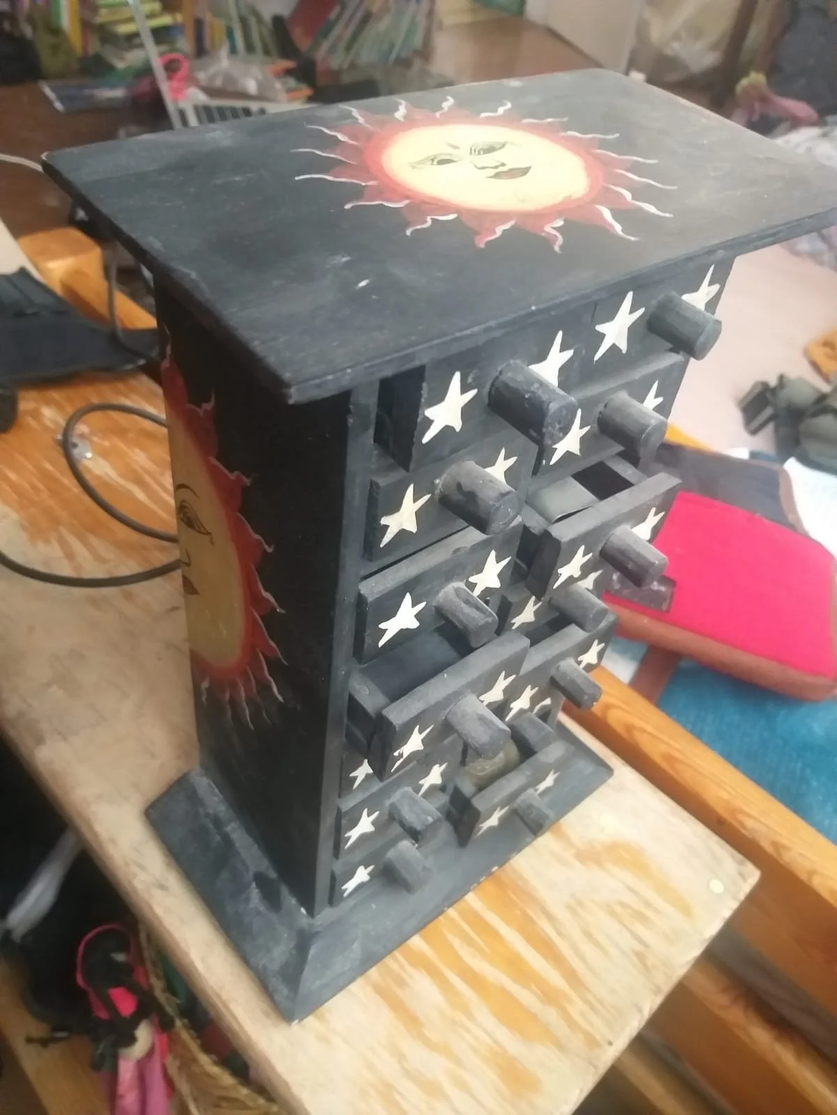 Carola Diez " Es una pequeña cajonera tailandesa, regalo de mi padre, que tiene unos 30 años conmigo. Tiene un sol y una luna pintados por detrás, y una estrella en cada cajón.  Representa para mi la diversidad integrada, todo lo que puede caber en l