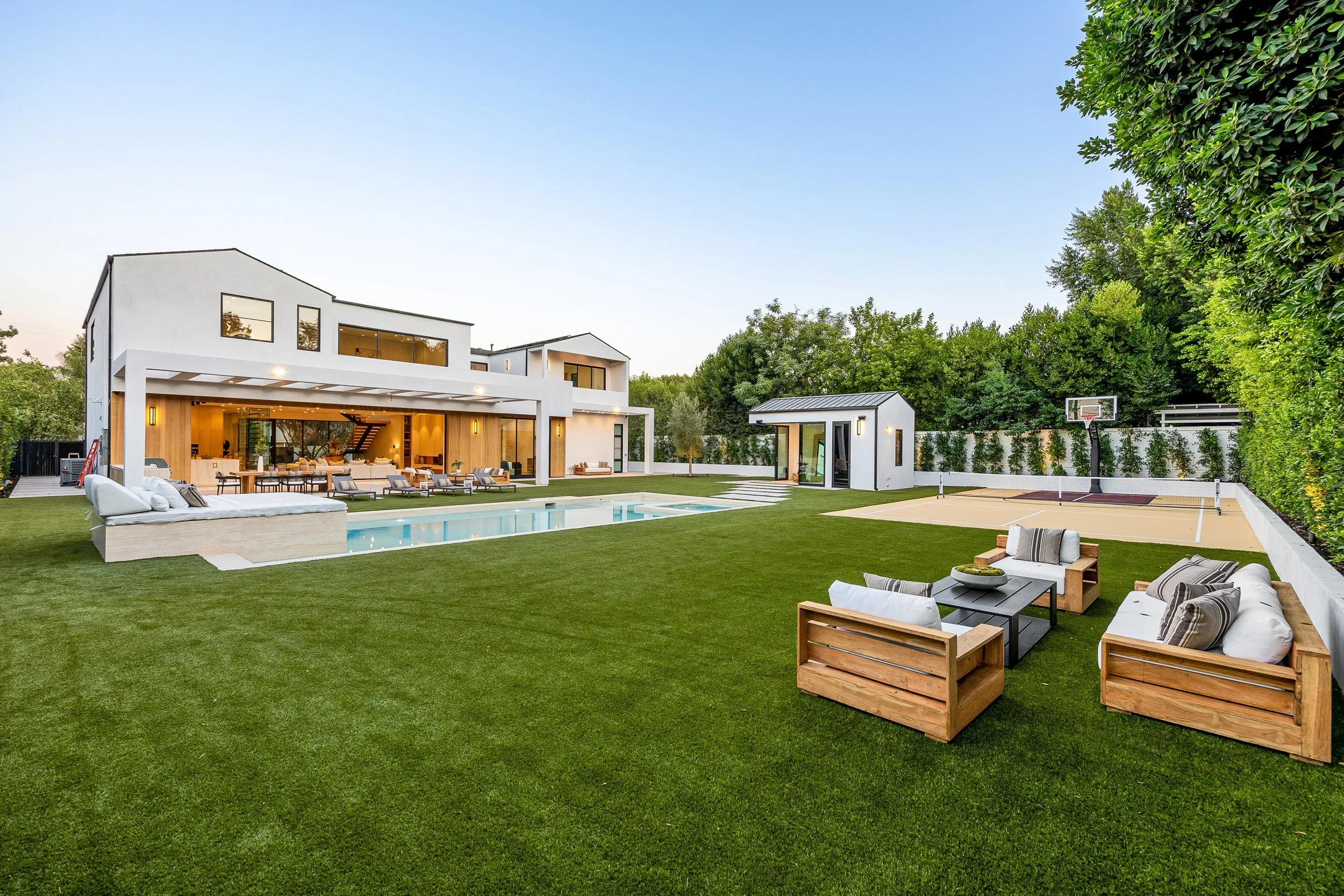 Luxurious backyard of a custom-built West LA home with a swimming pool and pickleball court.